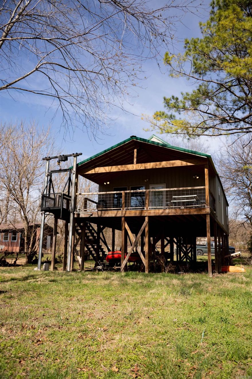 Discover the ultimate Ozark escape! This stunning 3-bedroom, 2-bathroom cabin, nestled on the banks of the pristine Spring River in Mammoth Spring, AR, offers the perfect blend of rustic charm and modern convenience. Beautiful Wood Interior: Experience the warmth and character of a true cabin with high-quality wood finishes throughout. Vaulted Ceilings: The open-concept living area feels spacious and airy, perfect for gathering with family and friends. With 3 bedrooms and 2 bathrooms, there's plenty of room for everyone to relax and unwind.  Enjoy your very own piece of property on the Spring River. Perfect for fishing, kayaking, or simply soaking in the natural beauty. Elevator Lift: A unique and convenient exterior elevator lift provides easy access from the ground level directly to the spacious deck. Fenced Area: A dedicated fenced-in space is ideal for pets or creating a secure play area.The property features its own well & septic. Located in the heart of the Ozarks, Mammoth Spring is home to Arkansas' largest spring and offers endless opportunities for outdoor recreation.