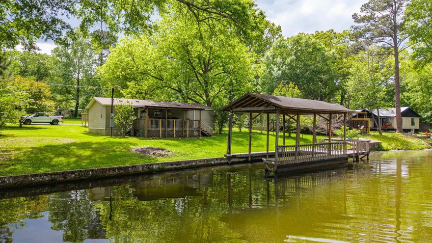 Welcome to your perfect lake escape! This beautifully maintained 3 bedroom, 2 bath home is full of warmth, charm, and endless possibilities for making memories on the water. Nestled on a rare flat, level lot, you can step outside and enjoy effortless access to the lake, whether it’s for morning coffee by the shore, afternoons in the sun, or evenings watching the water sparkle.  The covered boat dock is ready for days of boating, fishing, and fun, while the carport adds convenience. Inside, the home has been lovingly cared for and offers a comfortable, move-in ready space to relax after a day on the lake.  Located in a prime spot with a great location on the lake, this inviting property is perfect as a full-time home, vacation retreat, or weekend getaway. Come experience the easy, peaceful lifestyle of lakefront living!