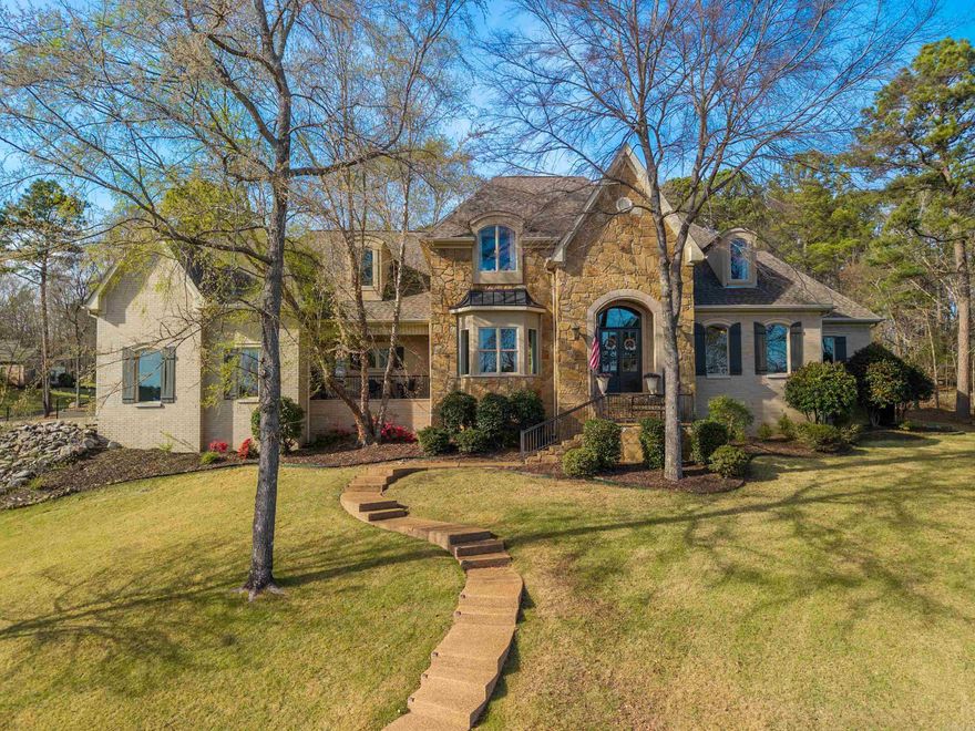 Welcome to the highly sought-after Red Oak Ridge, Hot Springs premier gated community. Nestled in a natural oasis surrounded by trees, this beautifully custom-built, updated home features a front balcony perfectly positioned for stunning Red Oak Lake views. The freshly painted, versatile floor plan offers 4 bedrooms, 3.5 baths, and an office used as a 5th bedroom. A mudroom with removable cubbies provides a perfect drop zone. The extra-large, fully remodeled chef’s kitchen boasts endless storage, a walk-in pantry, gorgeous new countertops, instant hot water, and premium appliances, including a WiFi Café double oven and 6-burner gas cooktop. Entertain in spacious living areas with updated lighting and two fireplaces featuring sleek new tile. The primary suite is a private retreat with new hardwood floors and spacious his-and-hers closets with added upper storage. Upstairs features 3 bedrooms with walk-in closets, 2 full baths (one with new tile), a new linen closet, upgraded insulation, and brand-new carpet. Complete with a freshly painted front door and shutters, a garden bed, and a garage with extensive built-in shelving, this pristine property is a must-see.