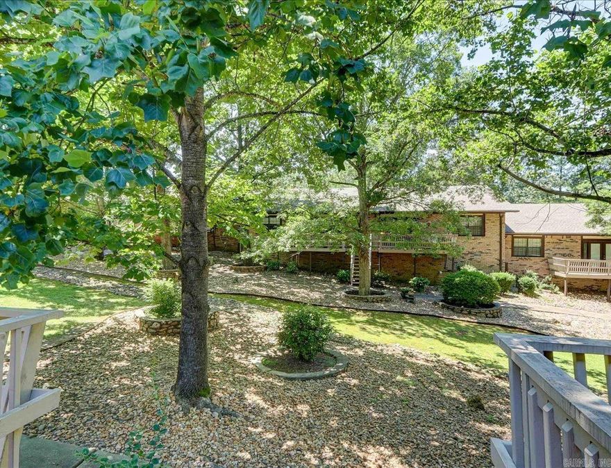 Welcome to this charming one-level, 2-bedroom, 2-bath condo, centrally located just minutes from Oaklawn Racing and Casino, shopping, and restaurants. This well maintained home features hand-scraped wood floors, a large kitchen, and a private, enclosed courtyard. BONUS for 2025 - just got a fresh coat of paint!  Back deck overlooking a wooded path, perfect for unwinding after a long day. The property has well-groomed grounds, a new roof, and covered parking. Step out your back door to a lovely walking path and appreciate the convenience of this prime location.   Agents - Call Showing service to schedule all showings.