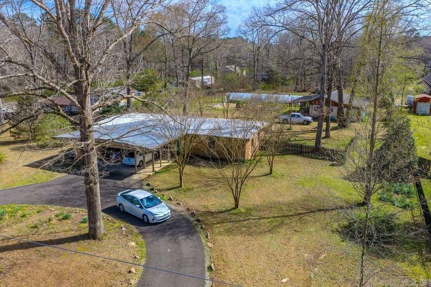 County living at its best! Three acres, move-in-ready home with great income potential. This immaculate, all-brick home w metal roof has been updated and well maintained. The kitchen features beautiful soapstone counters, freshly painted cabinets, new glass top stove, new stainless fridge, pantry, and breakfast bar. The large living/dining area has built-in shelves and south-facing doors that allow abundant natural light and open to patio. The home has easy-to-maintain tile floors thru out, recently updated bathrooms, energy-efficient windows with wood blinds, large laundry room and double carport with storage. The private, fully fenced backyard has a hoop house for year-round gardening, raised beds, large peony garden, and muscadines and blackberries that have produced income for the seller. The large shop also has versatile income possibilities as workshop, guest quarters, or studio. It includes tractor/storage shed, heated/cooled space, bathroom (composting toilet), screened porch, patio and greenhouse w sink. Beyond the yard is a lovely double-gated wooded area. Included are two adjoining lots. See agent remarks and additional docs for list of all improvements.