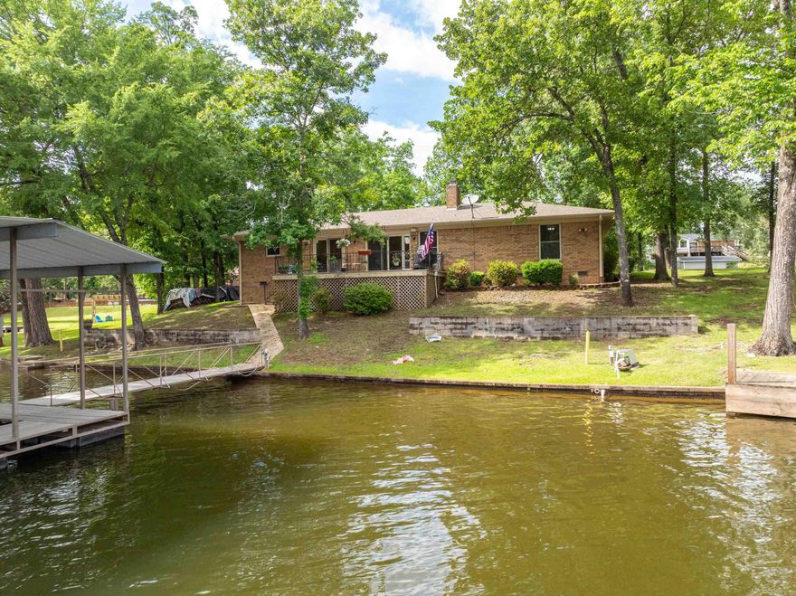 Lake Hamilton Gem – 3 Bed, 2 Bath Lakefront Home on 1.9 Acres Discover this rare opportunity to own a beautiful lakefront home with 1.9 acres of gently sloping land and 120 feet of prime Lake Hamilton frontage. This 3-bedroom, 2-bath residence offers comfortable living with stunning lake views from multiple rooms. Step outside to enjoy a very nice 2-stall dock, perfect for boating, fishing, or simply relaxing by the water. This dock has electricity and is ready for your boat lift. A pretty, tree-lined driveway welcomes you to the property, offering privacy and charm. You'll also appreciate the convenience of two freestanding garages, ideal for storage, lake toys, or a workshop. Next to one of the garages is an RV pad with an electrical hook up. With expansive lake views, mature landscaping, and ample space to spread out, properties like this are hard to find on Lake Hamilton. Whether you’re looking for a full-time residence, a vacation getaway, or a smart investment, this home has it all.