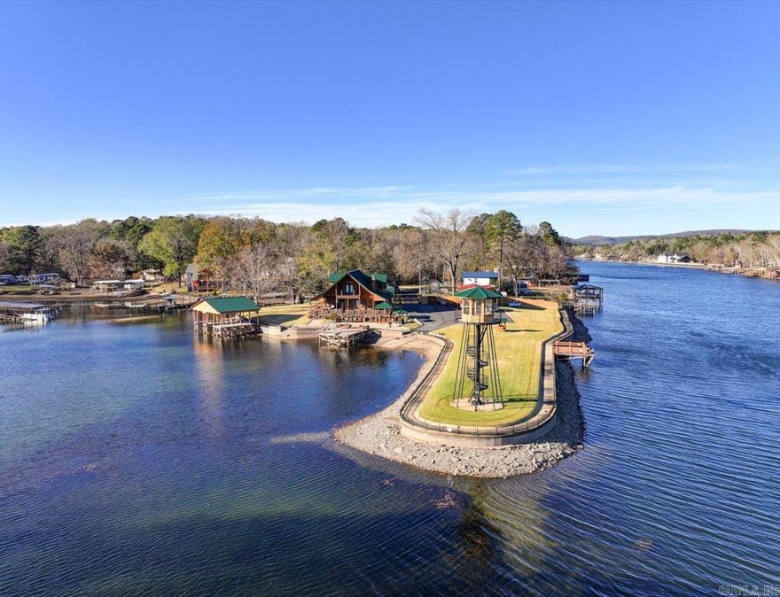 Your fully furnished dream home awaits you at 101 Muskogee Trail on beautiful Lake Hamilton. This unique property not only features a gorgeous 2527 sq ft craftsman style home as the primary residence, but also a 938 sq ft cozy guest house next door, 2 covered boat docks (1 with lift & 1 with storage room), 3 swim docks, hot tub, outdoor grills, generators, several storage sheds & a lighthouse sitting upon the point of this fully fenced & gated peninsula making this the complete package deal! Main home is artfully crafted with stunning wood from floor to ceiling & offers views of the lake at every turn. 3 bedrooms, 3 full baths, a safe room, kitchenette upstairs, an abundance of closet/storage space & more. 1 of the 2 fireplaces is an exquisite Vermont Casting. New roof & composite decking in '24.Guest house has 2 bedrooms, 1 bath, fireplace, deck, a huge storage room below, & A/C units were replaced several years ago. Sprinkler system for the lush St. Augustine grass & 2 carports. While this makes an amazing single family residence with plenty of room for entertaining, it would also be an ideal short term rental property with over 950' of lakefront, level land & room to expand.