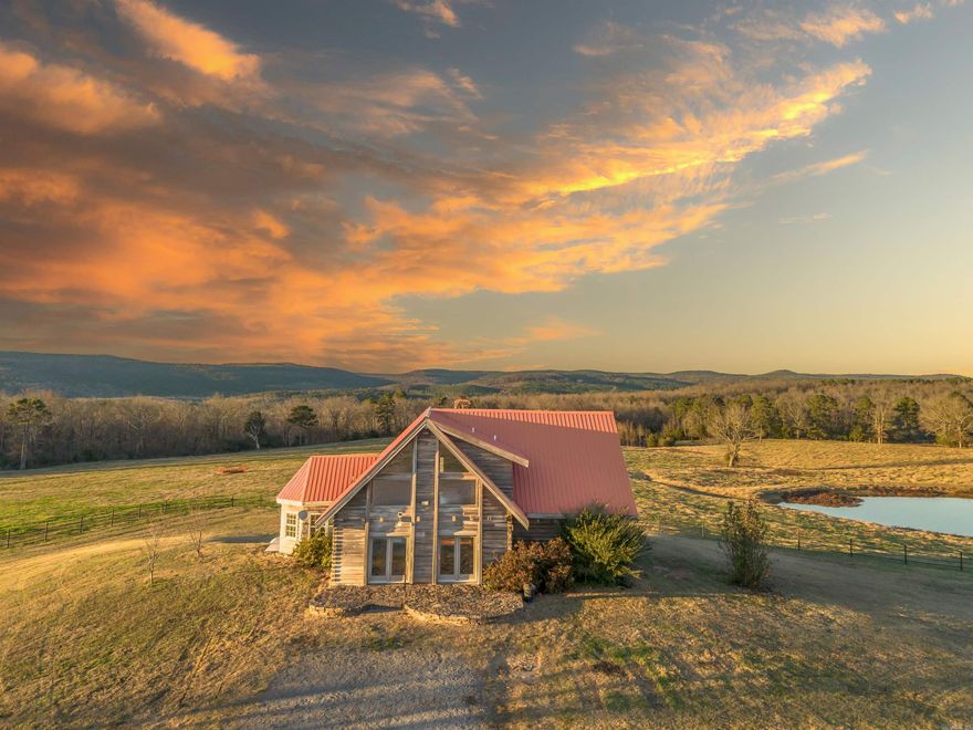 Welcome home to the ultimate property on 45 acres M/L with a stunning view of the Ozark Mountains! The house maximizes the view with its windows overlooking the meadow with three ponds and woods on the north side. This gorgeous cedar home has quality throughout. Walkout to the balcony view from both the living room and primary bedroom. Too many beautiful features to mention, with custom carpentry, granite countertops, full-house Generac generator, just to mention a few. This acreage isn't just beautiful, it's practical! Four large shops, including a 40'x80' red iron (3- 14' overhead doors), a 40'x60' red iron (with heated office and bathroom 2-14' overhead doors), 40'x40' metal truss shop, and 60'x36' drive thru wood truss. ALL have electricity. PIPE FENCE on main roads! 32 acre hay field with HUGE hay barn across road is also for sale with MLS #.