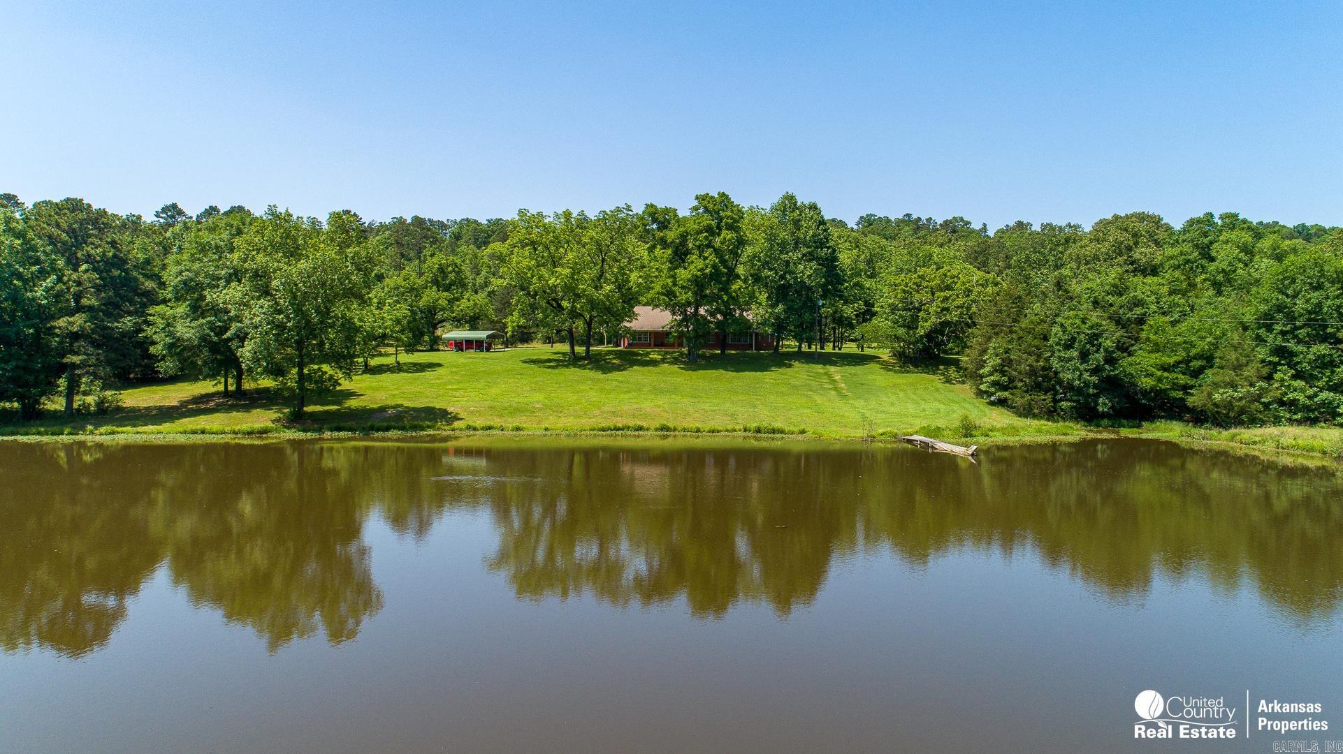 This property has 143 acres of mostly wooded land with private gated entrance. The land fronts a county road for just less than a half mile and is located about 20 miles south of Mena Arkansas and about 30 minutes from DeQueen AR. The home sits on a large lake stocked with fish and has a fishing pier. The almost 3,000 sq. ft. home has been updated and is like new inside. The kitchen has plenty of excellent cabinetry, granite countertops and is updated as well. The house has very spacious rooms, plenty of storage and a finished attic space. The property has a two car detached garage with full bathroom and is adjacent to a covered picnic area which is adjacent to a large 30X40 shop with overhead doors. This property offers much privacy, excellent hunting and fishing opportunities, and much more. Contact Agent For Restrictions that will apply if purchasing with less than original 178 acres.
