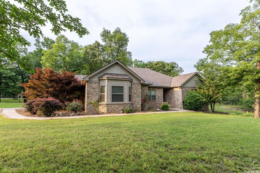 Peaceful scenic living with less than a 20-minute commute from downtown Little Rock! Upon entering this highly desirable & extremely limited neighborhood, feel yourself exhale and relax the moment you drive past Spring Lake.  This home is all on one level and has 3 bedrooms & 2.5 baths ready for you to call your own. It has a separate dining room and a well-designed kitchen including an adjacent breakfast nook. Large primary bedroom with a walk-in closet, bath area that has separate his & her vanities, a stand-alone shower and separate tub for soaking. The covered back patio with fans to keep you cool while you unwind. Two-car garage has peg-hook wall for those that like organization with a separate closet walk-in with shelves for storage. Seller improved & updated several items: a generator that will power the whole house, added gas logs to the fireplace, replaced all of the flooring, new roof in 2021, ALL new windows in 2020, new glass for primary bath shower, added beautiful wood built-in in living room, repainted interior & new trim in the whole house. Access to boat ramp & dock are included in the POA. Call 501.681.3198 today for your private tour! AGENTS: PLEASE SEE REMARKS.