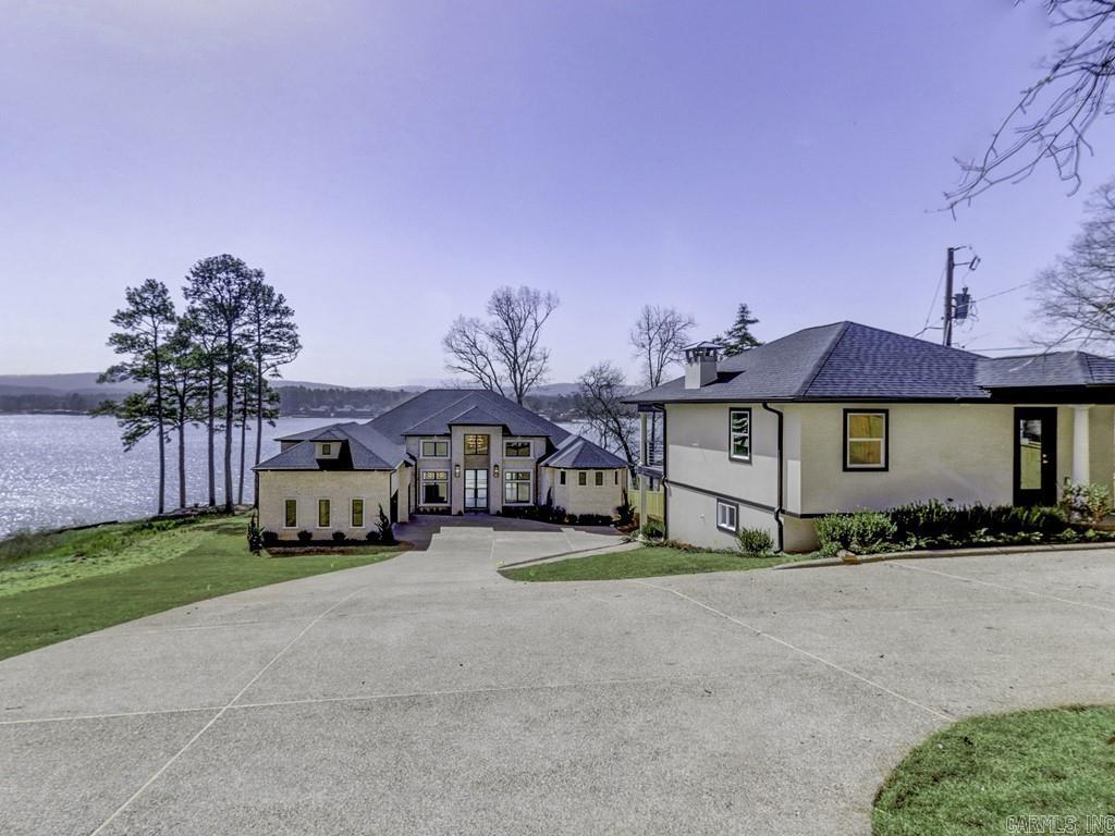 Lake Hamilton Luxury Lake Home. Stunning views and luxury living at it's finest. Soaring ceilings and the appointments you are looking for in your dream home on the lake that includes a guest house. Floor plan that maximizes views and open spaces perfect for relaxing together and entertaining. The kitchen is a chefs dream with oversized granite island, custom cabinetry, and large pantry. Beautiful fireplace in the living room for cozy conversations. The main ensuite features a coffee bar, fireplace and sumptuous bathroom, including his and hers potty rooms. Closets thoughtfully designed and offer and place for everything. Upstairs is a great game room, bedroom, and bathroom. The outdoor kitchen is perfect for lakeside entertaining and includes a fireplace. A double stall boat dock is included. The guest house has two levels. The upper level includes 1 bedroom, 1 bathroom, kitchen and is 632 sq. ft. The lower level is 572 sq. ft. includes 1 bedroom, 1 bathroom and kitchen. Close to Garvan Gardens and the tranquil lake life you have been dreaming of.