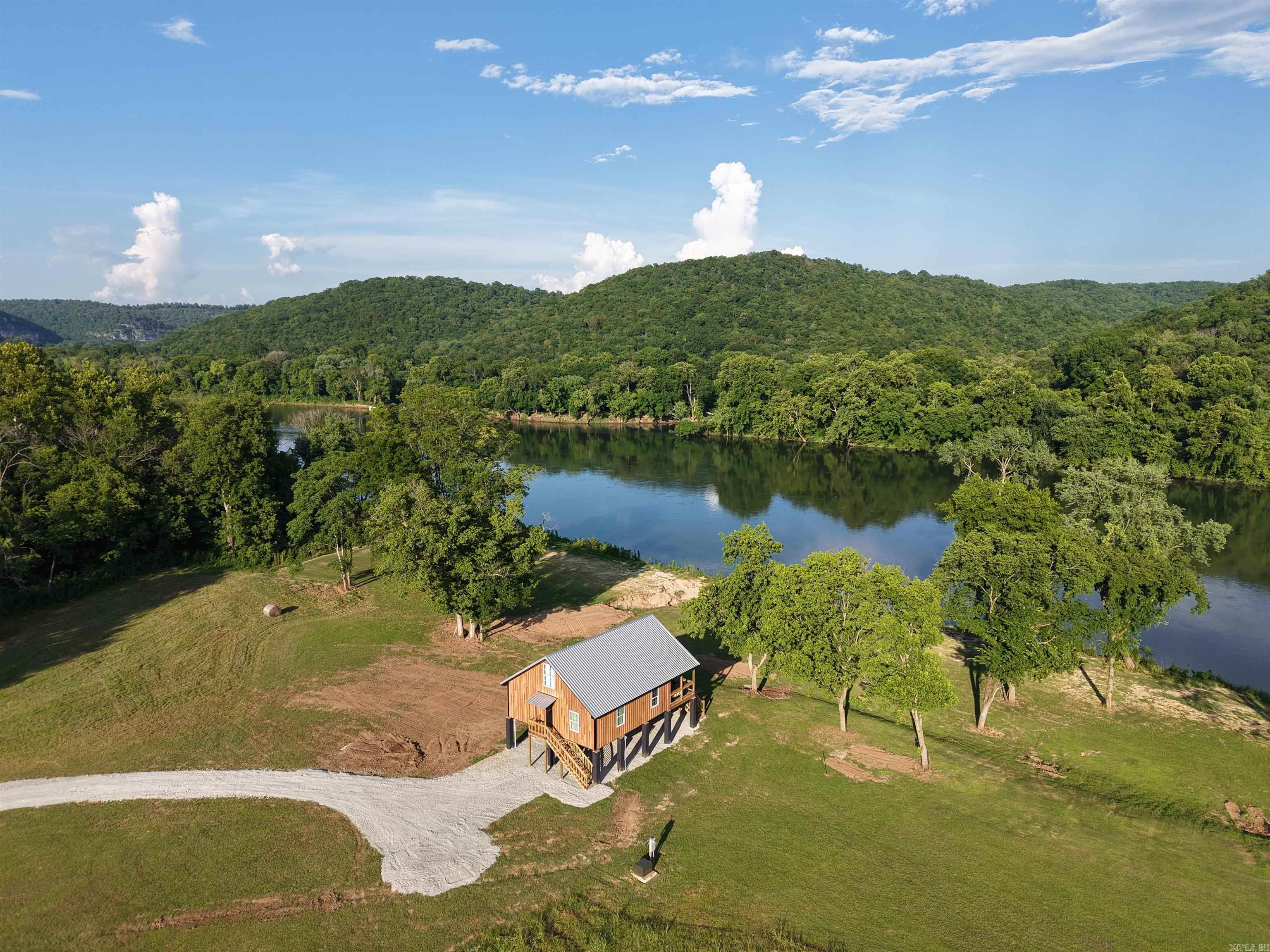 Welcome to Eagle Hollow Retreat, a custom-built riverfront cabin tucked away in a secluded setting near Mountain View and Melbourne, AR. This brand-new, fully furnished home features over 100 ft of White River frontage in a prime fishing spot known for rainbow trout and smallmouth bass, with eagles often soaring overhead. The cabin includes 3 bedrooms and 2 bathrooms, with custom wood finishes throughout. The bedrooms include a king bed in the primary suite, queen beds in the others. Each room are complete with a personalized vanity table. The kitchen is fully stocked and outfitted with custom butcher block countertops, crystal breakfast glasses, silver-plated flatware, and Pfaltzgraff dinnerware. A custom dining table and chairs add to the cozy charm. Enjoy river views from the covered 12x30 deck or relax by the firepit and seating area. The property also offers boat ramp access, a seasonal sandbar, and a fully graveled area under the home for extra parking or outdoor space. Whether you're looking for a permanent home, weekend escape, or income-producing vacation rental, Eagle Hollow Retreat delivers comfort, quality, and unforgettable riverfront livingālisted at $359,900!