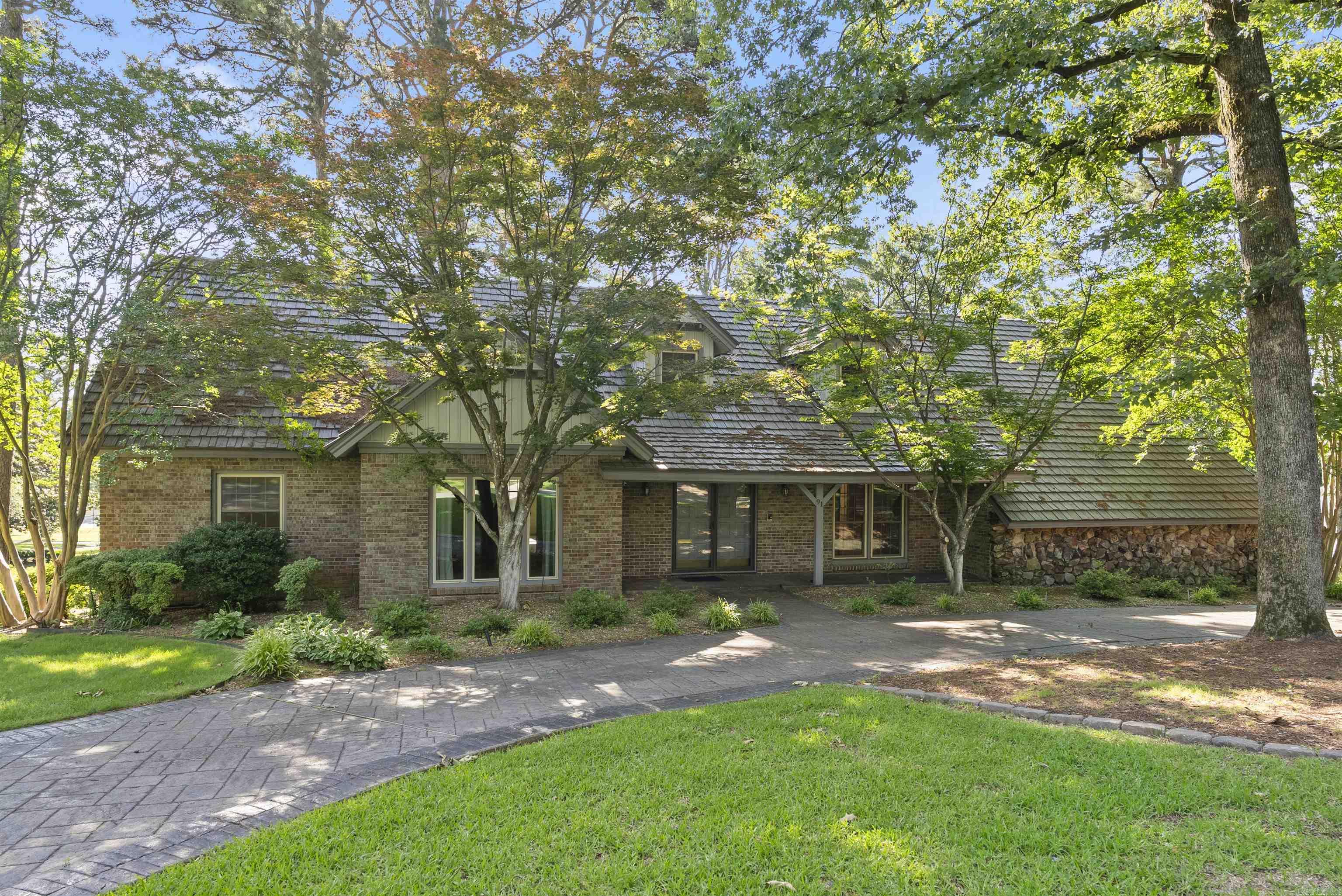 Located just steps from Pleasant Valley Country Club, tennis courts and golf course, this classic home sits on a spacious 0.69-acre corner lot and offers an ideal floor plan for comfortable living and entertaining. The two-story foyer with a circular staircase is adjacent to the living and dining rooms. The kitchen opens to a hearth room with a fireplace, wet bar, and built-in shelves. The kitchen features a cooktop, Jenn-Air double ovens, Sub-Zero refrigerator/freezer, ice maker, dishwasher, trash compactor, and Corian countertops. The main-level primary bedroom suite features a jetted tub, walk-in shower, dual vanities, and a walk-in closet. A second main-level bedroom suite is perfect for guests, in-laws, or flexible use. Upstairs includes four bedrooms (one could be used as a game room or an office), two baths, and a study nook. Beautifully curated outdoor living with a gunite pool, patio, landscaped yard, and full fencing. Additional highlights include a metal roof, new energy-efficient windows, whole home generator, a two-car garage, and circular driveway for extra parking.