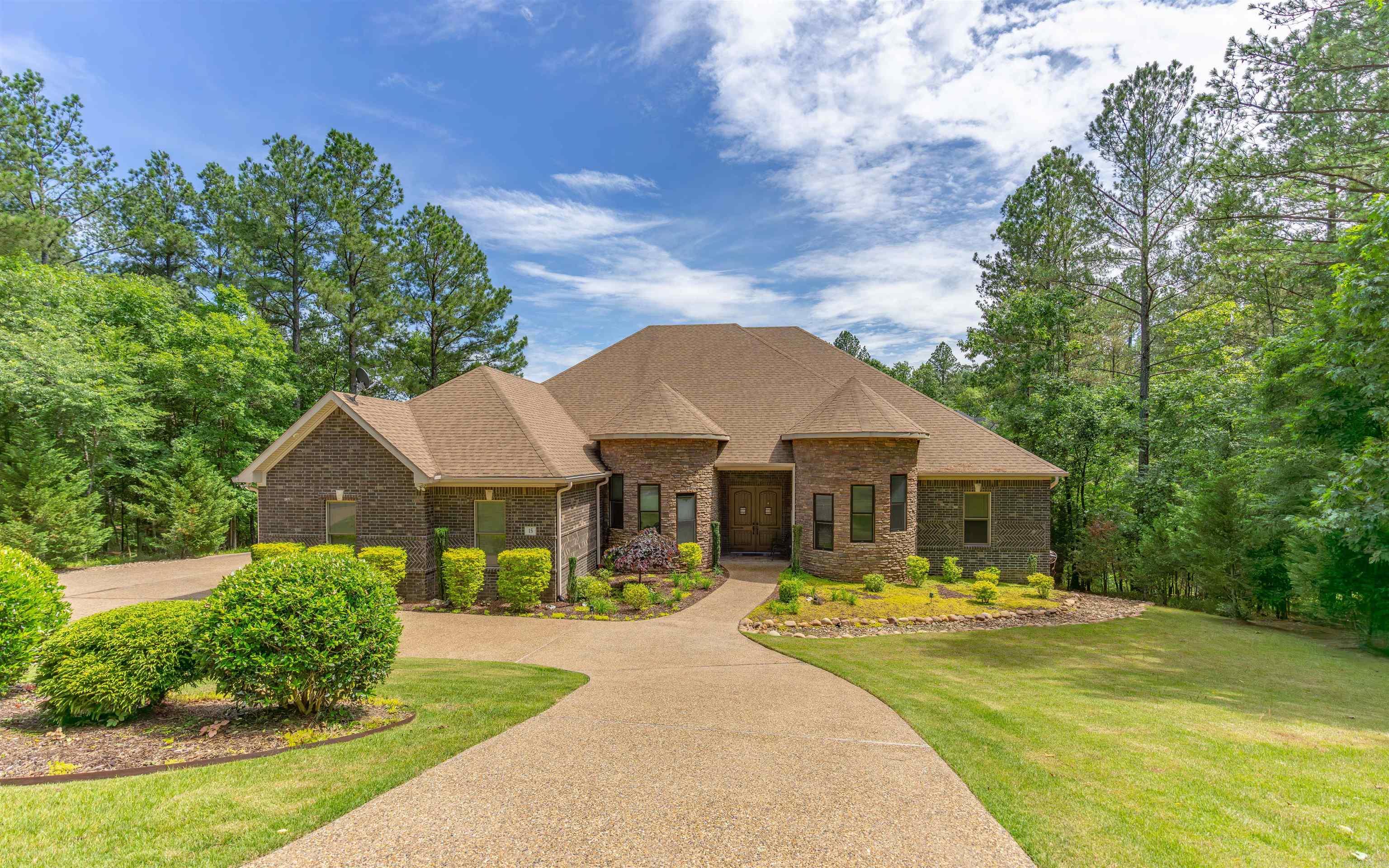 Stunning all-brick and stone lakefront home on Lake Granada in Hot Springs Village! This 3,606 sq ft single-level, handicap-accessible home features 3 bedrooms, 3.5 baths, and two master suites. Enjoy an open-concept layout, media room with pull-down screen, 14-ft ceilings in media and office, and 12-ft ceilings throughout. Gourmet kitchen boasts 2 islands, GE Café appliances, 5-burner gas stove with pot filler, custom cabinets, walk-in pantry, and hidden spice racks. Luxurious master bath with copper soaking tub and rain glass. Walk-in, wheelchair-accessible showers and closets with built-ins. Pella windows with remote-control blinds in media room, Culligan water softener, and barrel-ceiling foyer with hand-painted medallion. Professionally landscaped yard with Rain Bird sprinkler system drawing from the lake, circle driveway, and extra garage storage. Truly a rare lakefront gem in HSV!