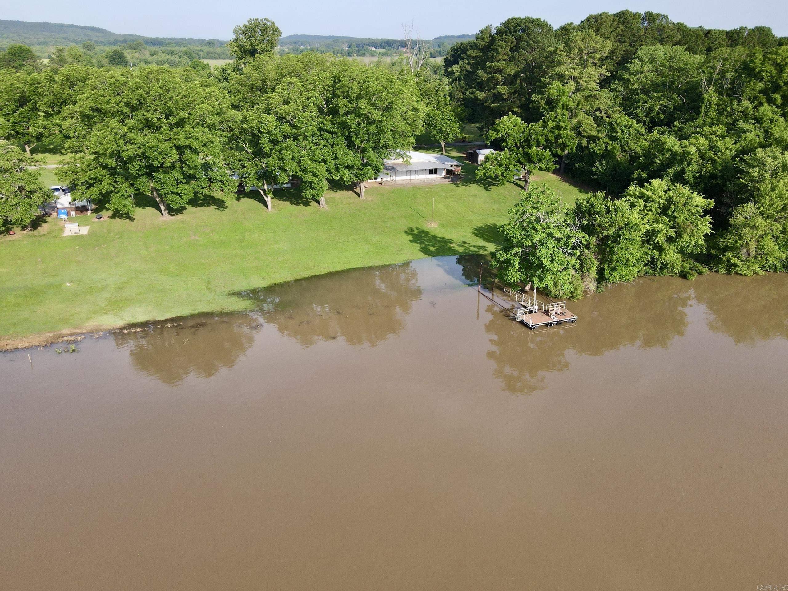 Welcome to a truly rare opportunity to own a stunning riverfront retreat with 300 feet of frontage on the Arkansas River. Set in a peaceful and private location, this property offers the perfect balance of functionality and natural beauty, just minutes from shopping, schools, and hospitals. The land has a park-like feel, highlighted by twenty mature, producing pecan trees and an enclosed cracking room built on concrete. Fully equipped with essential utilities, including electricity, rural water, propane hookup, and a 1,000-gallon septic system. Several useful structures are already established on the property. A 2,000 square foot shop offers a concrete floor and two large overhead doors, providing space for equipment storage, hobbies, or a working space. A 30 x 16 boat garage sits nearby, and while the 20 x 8 dock is currently in place, it will need some updating to return to full use. Additional amenities include a chicken coop with a concrete floor and a 160 square foot greenhouse for year-round growing potential. Itās a truly special offering that doesnāt come along often. This property is in the floodplain.