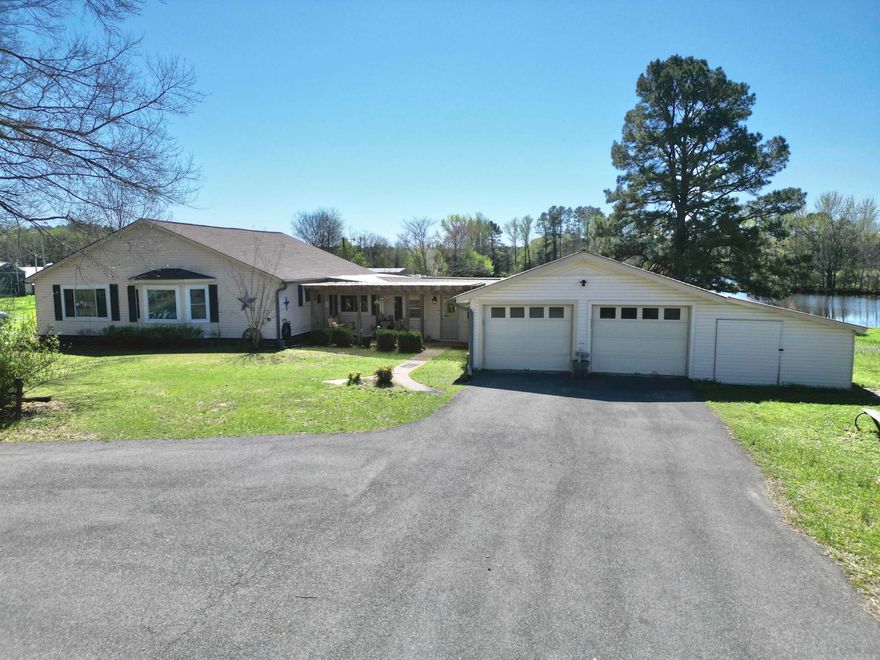 Enjoy peaceful country living on 11.33 acres with this well-maintained 1,682 sq ft home offering space, comfort, and beautiful views. The home features two living areas, an office, bonus room, and a craft room, providing plenty of flexibility for work, hobbies, and everyday living.  A nice breezeway with brick flooring adds charm and character while offering a great transition space between the home and garage. The property also includes a whole home generator, giving you peace of mind year-round.  Outside you’ll find a 2-car garage, barn, she shed, and multiple outbuildings, offering plenty of room for storage, projects, or animals. Relax or entertain on the covered patios overlooking two large stocked ponds, creating a beautiful and peaceful setting.  A blacktop driveway leads to this versatile property with room to enjoy country living, gardening, recreation, or simply taking in the scenic pond views.