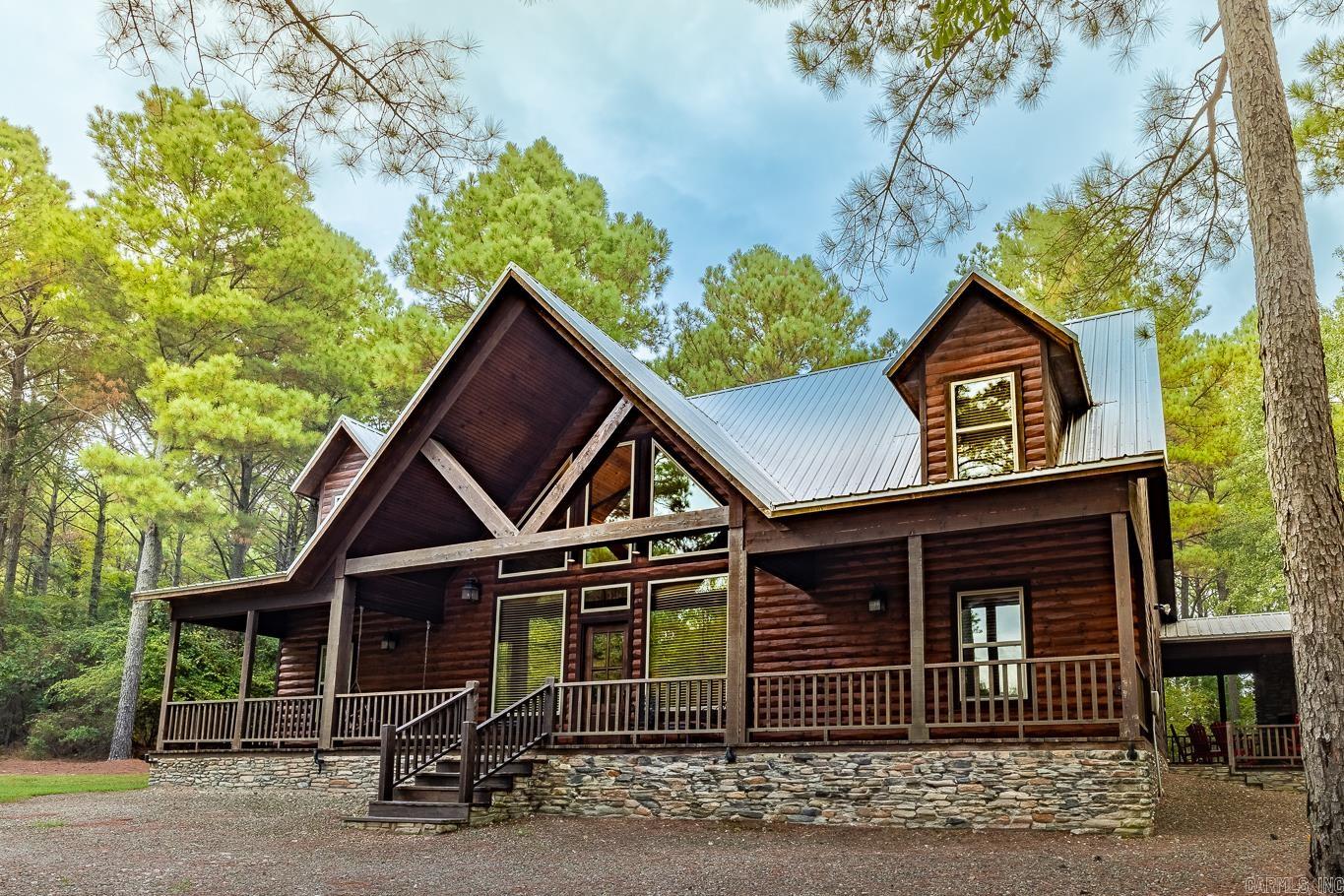 Welcome to The Ponderosa, a stunning two-story log cabin nestled in the serene Kaniatobe Trails subdivision. Has been used a short-term rental for years. This spacious cabin features four cozy bedrooms and three modern bathrooms, making it an ideal getaway for families or groups. Unwind in the luxurious theater room or challenge your friends to a game of pool in the loft. Enjoy evenings by the indoor or outdoor fireplaces, and take advantage of the hot tub for ultimate relaxation under the stars. The kids will love the play set, the arcade machine with you choice of game, and you might even spot deer wandering nearby! Conveniently located just 0.5 miles off Hwy 259 and right behind First Bank. The Ponderosa combines rustic charm with modern amenities. Don’t miss your chance to experience this enchanting escape in the heart of Hochatown!