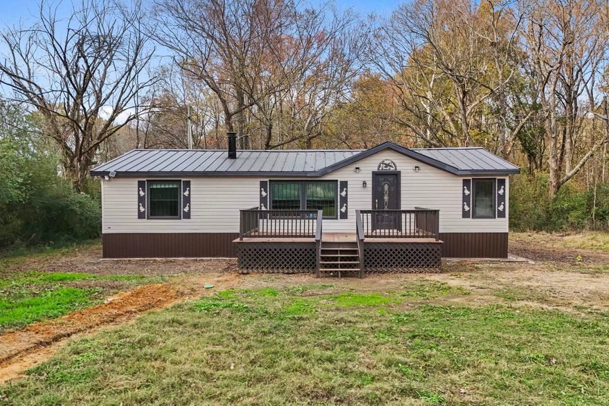 Escape to your own private retreat with the charming 3-bedroom, 2-bath manufactured home on 4.74 acres. The spacious family room, complete with a cozy fireplace, opens to a kitchen featuring new appliances and abundant storage.  The primary suite boasts a walk-in closet, dual sinks, and a walk-in shower. Additional storage is available in the laundry room. Enjoy the outdoors on newly built decks at the front and back. Complemented by a new septic system, a wood fence and a gated entry. The wooded acreage offers seclusion and endless possibilities for your lifestyle.