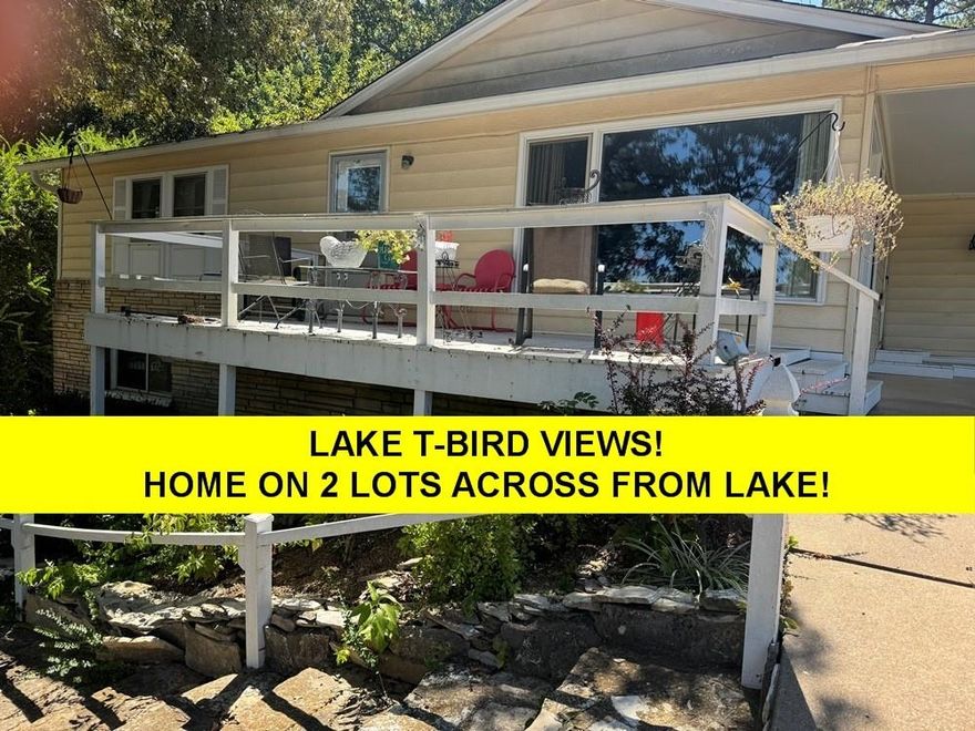 ACROSS FROM LAKE THUNDERBIRD! 2 LOTS- Over 2000 sq ft- includes Mother-in-law suite.  Upstairs vintage hardwood flooring-great character! Eat-in kitchen lots of cabinets and storage.  Huge living room looks out to T-Bird views thru big windows (views best fall-winter). 2 roomy bedrooms on main level-share full hall bath-laundry on main level. Large bonus room views nice patio with native stone walls.  Numerous uses for bonus room - has native stone wood burning fireplace (currently has electric logs) and large storage closet- with easy access to backyard. Newer storage bldg in back.  Lots of vinyl replacement windows, low maintenance steel siding. Downstairs has family room along with bedroom, 3/4 bath & lots of additional storage.  Newer h/a (Elec w/propane back-up), roof, gutters, water heater-see disclosure for ages. Washer/dryer conveys at closing, new concrete septic 2012. Lot next door - great spot for garage or shop. Home is occupied requires appointment. #2417