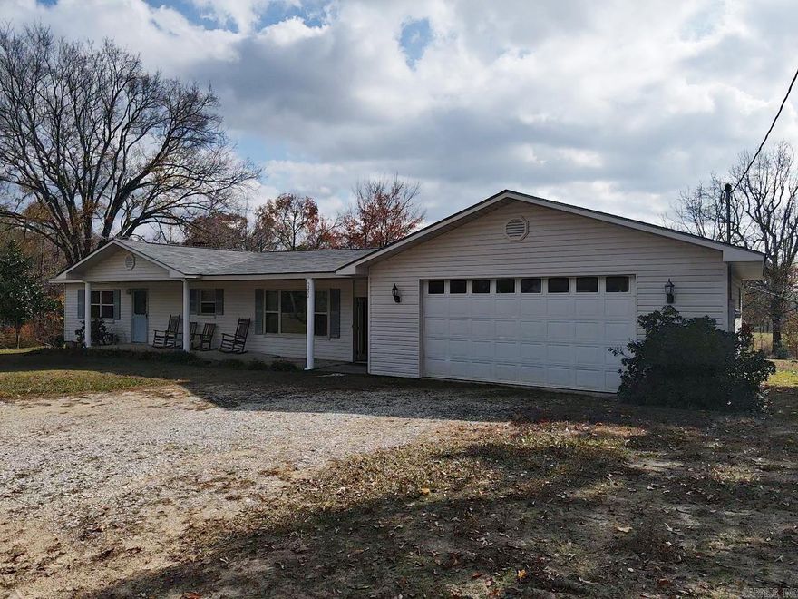 On this beautiful property is the 1300 sq ft home listed in this description as well as a 1024 sq ft 3/2 mobile home, set up and fully functioning, plus a 60 X 30 metal shop.  It is great for a big family or for rental income in the future. The concrete block home has insulation inside the blocks making utilities very low.  The 2-car garage is heated by a wood stove and is attached to the house with an enclosed dog trot passageway.  The wood stove from the garage is piped over into the house for heat. The shop has 2 bay doors and lots of room for any type of work. The covered back porch and additional shed look out over the acreage. Located close to all surrounding towns, this is a real gem of a property.  It is ready to be brought up-to-date or is great as it sits.  The property is sold "as is." Call for a showing today.  See agent remarks.