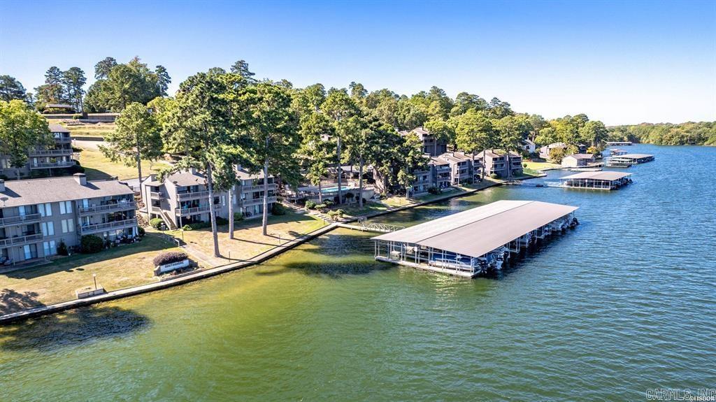Welcome to your dream lakefront retreat! This stunning 3-bedroom, 3-bathroom fully furnished condo offers the perfect blend of comfort, luxury, and outdoor enjoyment. Located in a stunning lakeside location, you'll experience breathtaking views and year-round water access with your own covered boat slip. Inside, you'll find spacious living areas designed for relaxation and entertainment. A wet bar and game room make hosting guests a breeze, while the open-concept layout seamlessly connects the modern kitchen, dining, and living spaces. Each bedroom is generously sized, ensuring privacy and tranquility. Step outside and soak in the beauty of Lake Hamilton on your two covered patios also enjoy cooking on the grilling patio. Take advantage of the community amenities, including sparkling swimming pools and tennis courts, offering endless opportunities for recreation and leisure. Whether you're seeking a weekend escape or a full-time residence, or an investment property this exquisite condo is the perfect place to enjoy lakeside serenity with all the conveniences of this prime location, including nearby restaurants, shopping and marinas with a quick trip to Oaklawn or Downtown Bath H