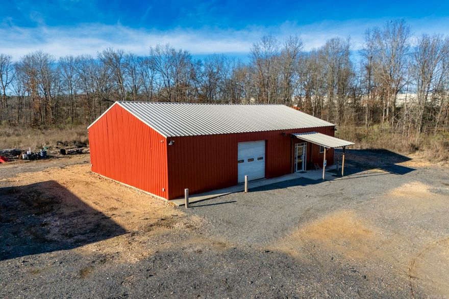 Located at 1595 N Elm St, this versatile commercial property offers an excellent opportunity for investors or owner-users seeking proximity to major industrial operations. The property is situated directly next to the Georgia-Pacific Mill and near the EDCC new transload rail facility, providing strong logistical advantages and long-term demand drivers.  The metal building features a large open-span interior with concrete floors, high ceilings, spray-foam insulation, and bright overhead lighting, making it ideal for warehouse, shop, light industrial, storage, or service-based operations. A roll-up door allows easy equipment access, while framed interior areas offer flexibility for office space or additional build-out. The property also includes a finished kitchenette and bathroom for employee or operational convenience.  Positioned on a level lot with gravel parking and easy road access, the site benefits from its industrial-adjacent location with expansion potential. This is a solid investment opportunity in a proven industrial corridor with strong infrastructure and nearby rail and manufacturing support.