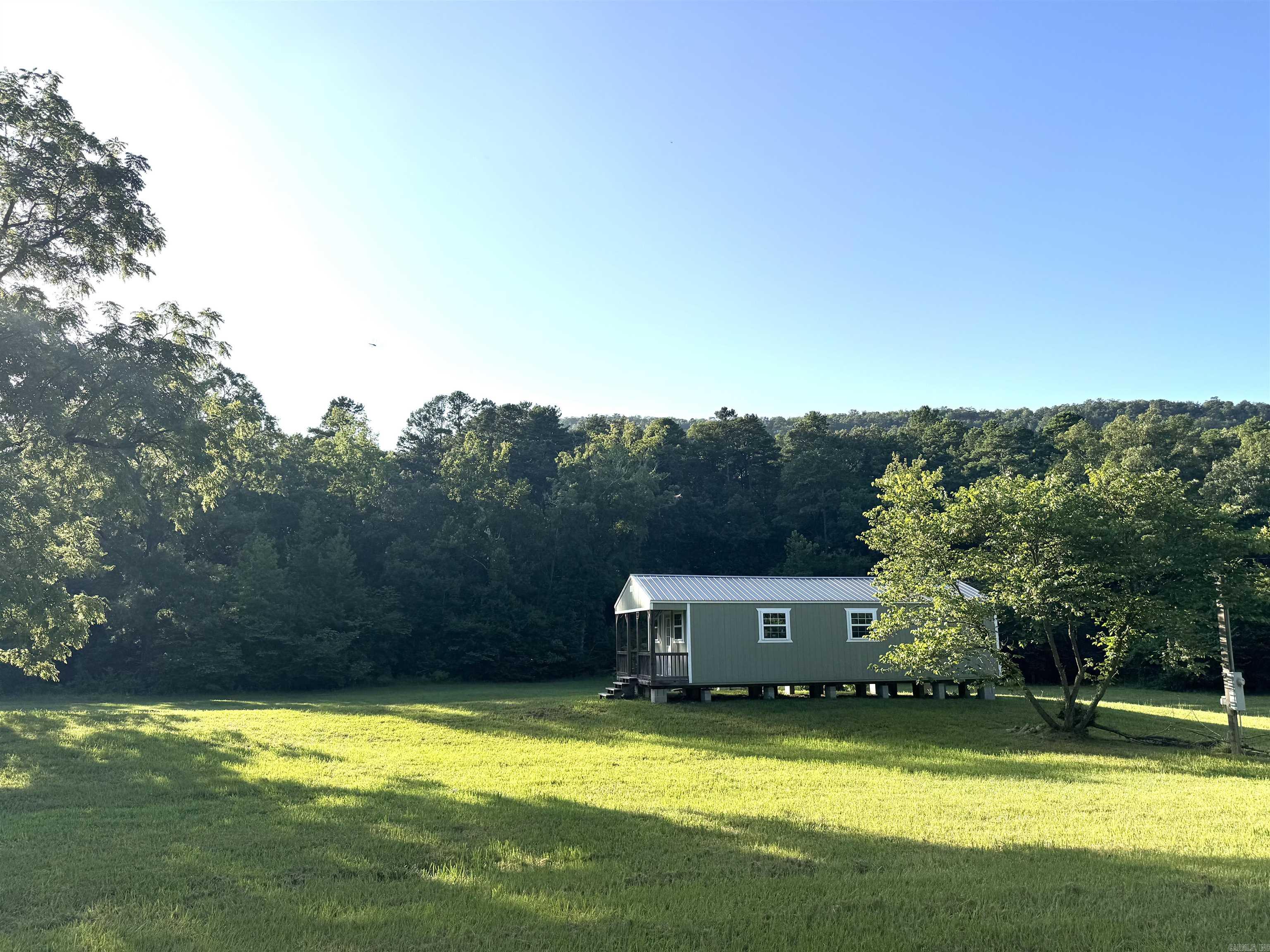 COME AND SEE THIS ABSOLUTELY STUNNING PROPERTY!! This property has so much potential and many opportunities for yournew home place, to vacation rental cabins being right next to the canoe rentals on the Caddo River!! This property is very unique with theyear around winding creek with a beautiful setting, the 12 acres run up the mountain side and it has beautiful mountain views all around you! The deep dense woods on the mountain side great for a hunting cabin up on the mountain is for a hunter's dream!! Lots of deer and wildlife all over this property!! The bottom side of this property would be fantastic place to start a Plant nursery because it has a Creek that runs all along the bottom side for easy water access. Also, a great place to put in a fruit tree orchard. The small, tiny shed could be made into a cabin or tiny home it also has electric and city water on the property. This is a jewel of a property! Just absolutely Beautiful!!The picture on the bridge is Caddo River just up the road. Tambra today to see!