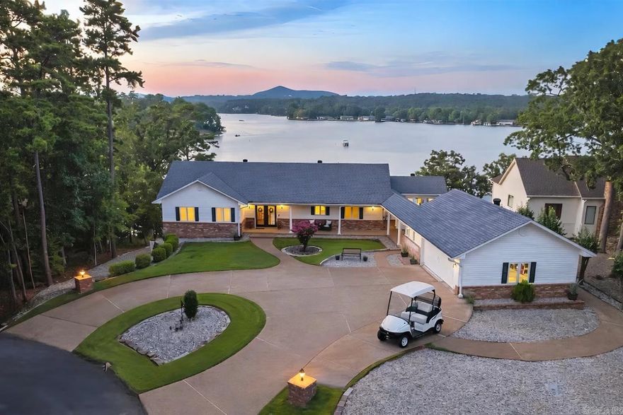 Experience lakefront luxury in Hot Springs Village with this fully furnished executive retreat on Lake Balboa, a 944-acre recreational lake. Positioned on a private .56-acre cul-de-sac lot with level circular drive, this polished two-level home offers 3,630 sq ft, 4 bedrooms, and 3.5 baths with three en-suites—ideal for luxury living, second home, or investment property. Fresh modern design showcases engineered wood flooring, dual electric fireplaces, and walls of windows in the Arkansas Room/office capturing serene water views. The well-appointed layout flows seamlessly to three expansive deck areas for elevated indoor-outdoor living. Enjoy peace of mind with a Generac® generator, smart lighting, smart locks, and security cameras. Outdoor features include a covered boat dock, kayak launch, boat, two kayaks, and Hobie paddleboard convey, offering immediate lake enjoyment. The oversized garage with breezeway accommodates 2 cars plus golf cart/workshop with attic storage. Located in a premier gated golf and lake community with 11 lakes, 9 golf courses, marina, pickleball, trails, dining, and more. A rare turnkey lakefront opportunity.
