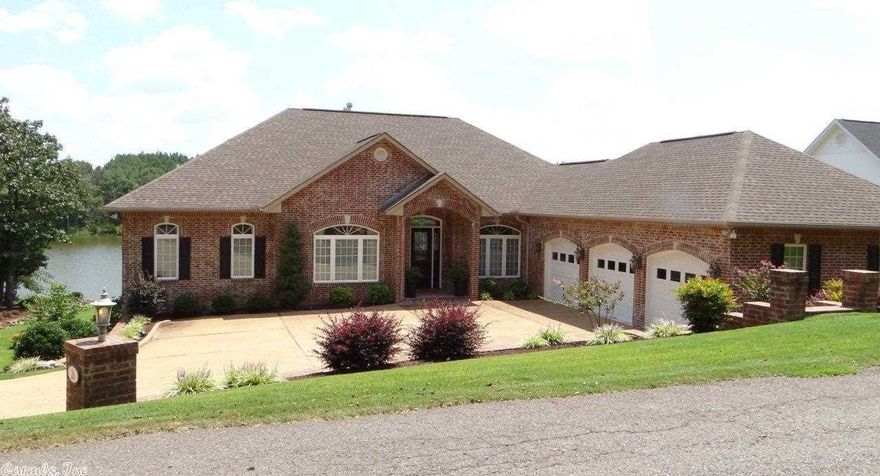 Custom designed features and extras include premium hardwood, tile and carpet flooring; custom window treatments, upgraded fixtures, king crown molding, premium cabinets, chef’s kitchen; granite counters & built-in vacuum,intercom pre-wired; 3 gas fireplaces; generous lighting, ceiling fans, outside floodlights; built-in surround sounds both levels; zoned air conditioning; 3 bay oversize garage; lake siphon irrigation system; buried 250 gallon propane tank; stone seawall & boat dock. ***AGENT SEE REMARKS**