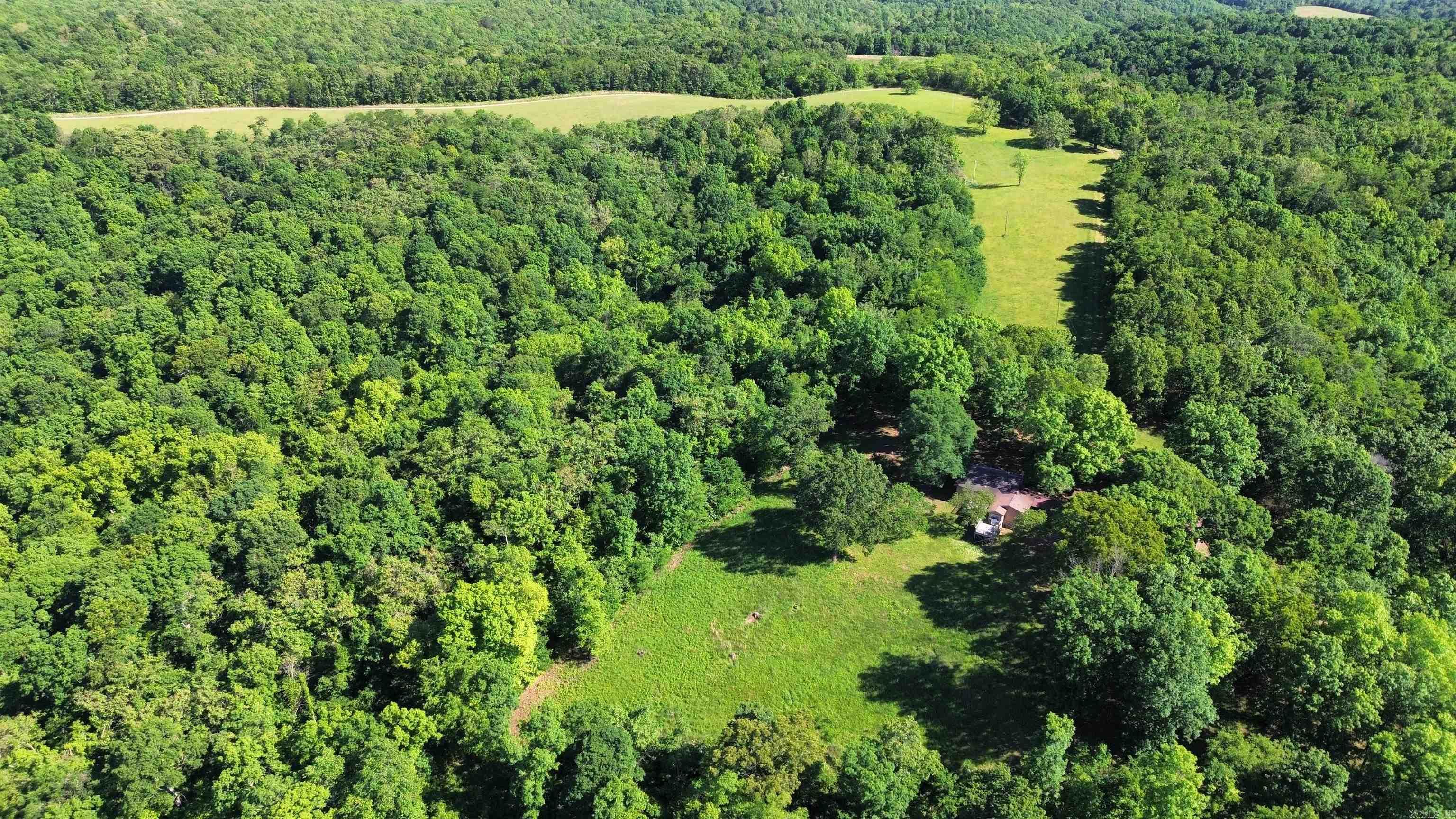 Explore the allure of the Ozark Mountains with this expansive 833.66-acre property, perfectly positioned near communities like Mountain View, Melbourne, and Batesville. Offering an exceptional mix of seclusion and community access, enjoy the essentials nearby while maintaining the privacy of your own vast retreat. This property is an outdoor enthusiast’s dream, rich in diverse opportunities such as hunting, farming, and timber management. The White River is just a stone’s throw away for fishing, and Guion Park provides a serene setting for leisurely walks, merging recreational activities with profitable land management. Inside the welcoming residence, find three cozy bedrooms, including a spacious primary bedroom, and two well-appointed bathrooms. The home fosters a warm atmosphere for both relaxation and social gatherings. Notable amenities include a wood-burning fireplace and efficient central heating and air conditioning, supplemented by a full-house propane generator. The owners are open to subdividing the acreage, all Priced at $1,250,000.