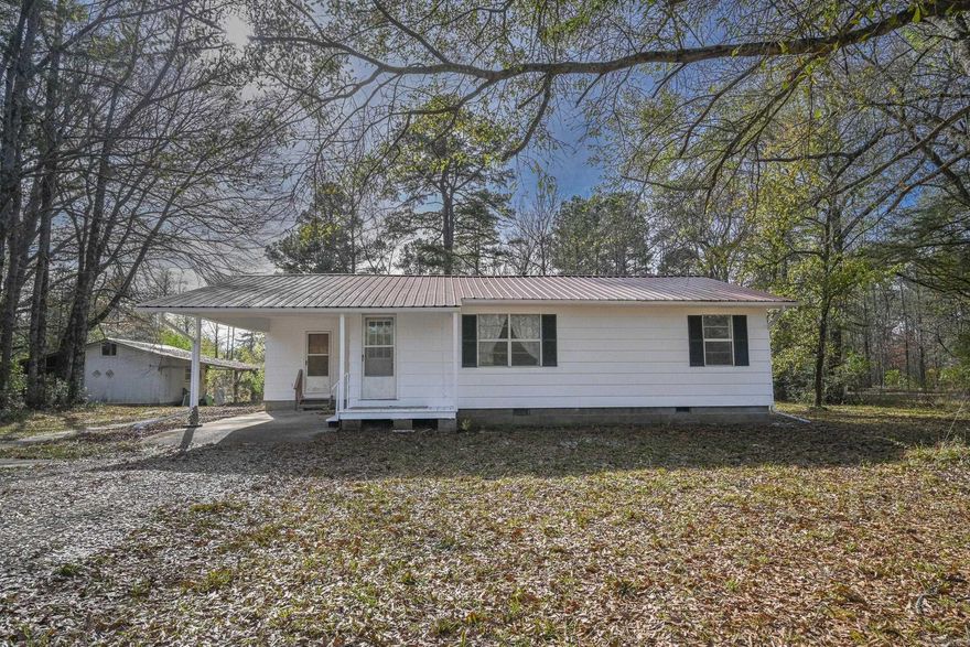 Charming 3-bedroom, 1-bath home built in 1960, offering 1,456 sq. ft. of comfortable living space. The spacious living room flows into a bonus room off the third bedroom, making it perfect for a sunroom, home office, or additional lounge space. All bedrooms are generously sized, and the home has been recently updated with all brand-new flooring: carpet in the living room, bedrooms, and bonus room, and vinyl in the kitchen, bathroom, and utility room. The property features a 1-car attached carport and a shop with a covered work area—perfect for storage, hobbies, or projects. Sitting on 1.10 acres just outside of town, this home offers peace and privacy while still being close to town.