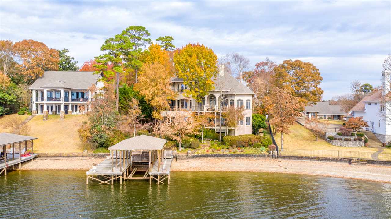 Custom Built and Designed By Current Owners, this spacious Lake Hamilton Home offers western lake view with magnificent year-round sunsets, lush landscaping, and stationary boat dock. Main and upper levels include 3477sf. 1680sf lower level has two living areas, full kitchen and bedroom suite. Other features: 2 fireplaces, safe room, attic storage and lake irrigation system.