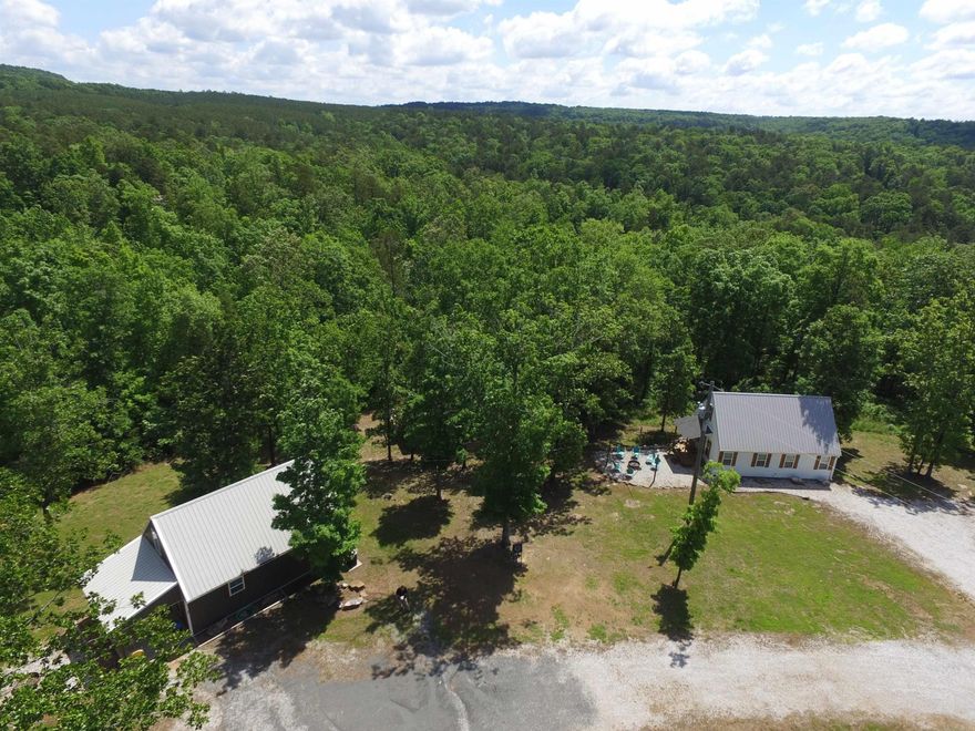 TURNKEY AIRBNB WITH PROVEN CASH FLOW! Glamping in the Ozarks has become popular and these cabins are some of the best in the area. Each heated and cooled cabin has a large bedroom and a sleeping loft as well as an electrical hook-up for an RV for overflow guests. One cabin has two bedrooms plus the loft. For your enjoyment, there is a beautiful wood fired sauna with an outdoor shower located between the cabins,. Enjoy evenings around the campfires making s'mores and memories, telling stories and counting stars. In the morning take a short walk to the bluffs at Midway bridge and jump in the lake to start your day.  Or start your day in the sauna followed by an outdoor shower.Then take the short drive to one of 3 nearby marinas for a day on the lake. This unique opportunity can be yours to enjoy! There is an additional RV parking pad to increase your income stream.  Come see it all soon.