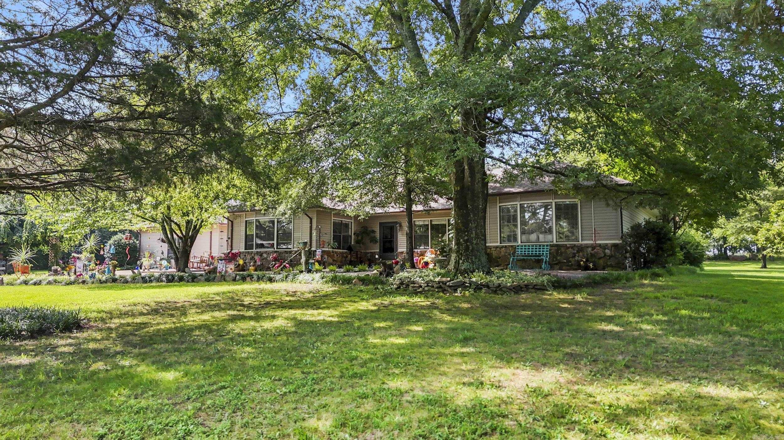 TAKE A LOOK AT THIS RARE FIND!! Here is your opportunity to own a little piece of "Heaven on Earth" on this very private 16 acres that is less than 5 mins from the interstate & exactly 7 minutes to the hospital. This custom-built home is nestled on the back of the property & includes 4 bedrooms, 3 living areas to include a sunroom & bonus/game room, formal dining room, basement for storm shelter, large utility/mud room off back of house, greenhouse room for plants, 1500 sq foot shop with a large attic area for storage & a great patio with pergola in the backyard. The kitchen has a spacious walk-in pantry, double oven, breakfast area, built-in buffet/hutch & a trash compactor! Other features include walk-in closets, tongue & groove solid wood paneling, gorgeous rock fireplace, HVAC that is 1 year old, roof 2018, beautiful landscaping, & more. Call today to see this gorgeous place that has been very well maintained! AGENTS SEE REMARKS
