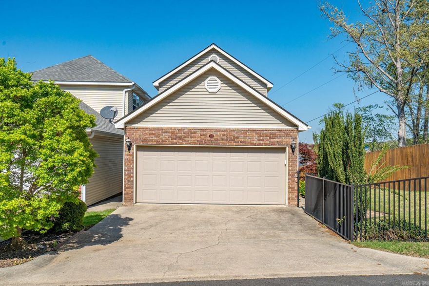 This enchanting townhome is located in the charming gated enclave of "Majestic Lake Village," situated along the shores of Lake Hamilton. End unit placement offers a fully fenced side yard, perfect for privacy and pets. Pull into your 2-car garage to enter this freestanding townhome (you own the land on which it sits!). The walk-in level hosts open-concept kitchen / dining / living spaces featuring high-style interior finishes including:  hickory wood flooring, quartzite countertops + backsplash, stainless appliances, gas cooking + fireplace, new cabinets, and updated fixtures. Upstairs, both bedrooms are accompanied by en-suite bathrooms, with the master suite offering direct balcony access. Enjoy stunning water and mountain vistas from one of two covered balconies.  Majestic Lake Village's POA dues of $100 per month are some of the most conservative in Hot Springs. Enjoy all that gated Majestic Lake Village has to offer, including fishing off of the boardwalk, playing catch at the waterfront, or swimming off the dock. To maintain the community's charm, nightly rentals are not permitted. This residence is truly a splendid place to call your own!
