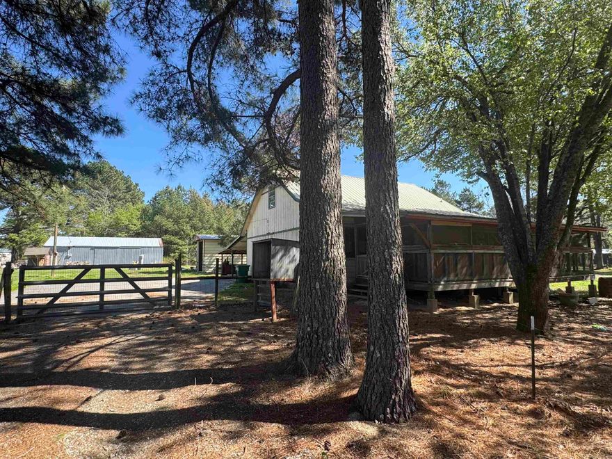 Tucked beneath a canopy of beautiful pine trees, this 4 bed, 3 bath home sits on an incredible 2.97 acres spanning two lots (13 & 14)-one of the largest properties in the area! With 1,486 sq ft, a spacious screened-in front porch, and multiple outbuildings including a large shop, this property offers endless potential. The dreamy, tree-lined driveway creates a private, peaceful setting that truly stands out. Inside, the home is ready for your personal touch- perfect for investors or buyers looking to create their dream space. With land, space, and versatility hard to find at this price point, this property is priced to sell and full of opportunity. Don't miss your chance to own a unique slice of country living with room to grow!