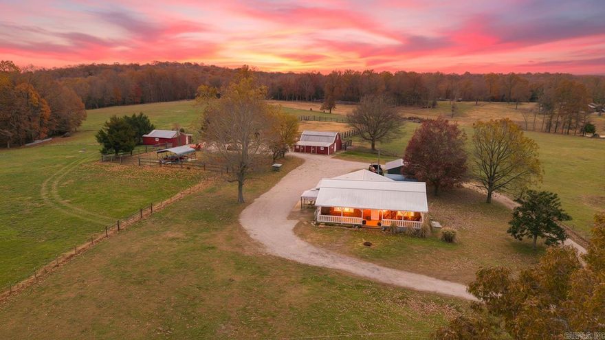 Country Charm on 20 Acres Experience peaceful Ozarks living with this 3-bed, 2-bath farmhouse on 20 fenced and cross-fenced acres. The home features newly installed metal siding and roof, hardwood, tile, and LVP flooring. The kitchen includes quartz countertops, an island, electric stove, dishwasher, and refrigerator (note: current kitchen refrigerator will not stay, but one from the barn will return). Extra closets, an oversized laundry, and a mudroom add daily convenience. Private well and septic recently cleaned. Step outside to a deep covered front porch with ceiling fans, perfect for morning coffee or evening relaxation. The master suite opens to a concrete pad ideal for sunsets or a future addition, while a gazebo patio off the mudroom adds another great gathering space. The property includes three barns—one with loft and storage, another with three horse stalls and automatic water—plus two carports and a circle drive. Approx. 14 acres pasture, 6 acres woods, a pond, and mature trees complete this charming Ozarks setting.
