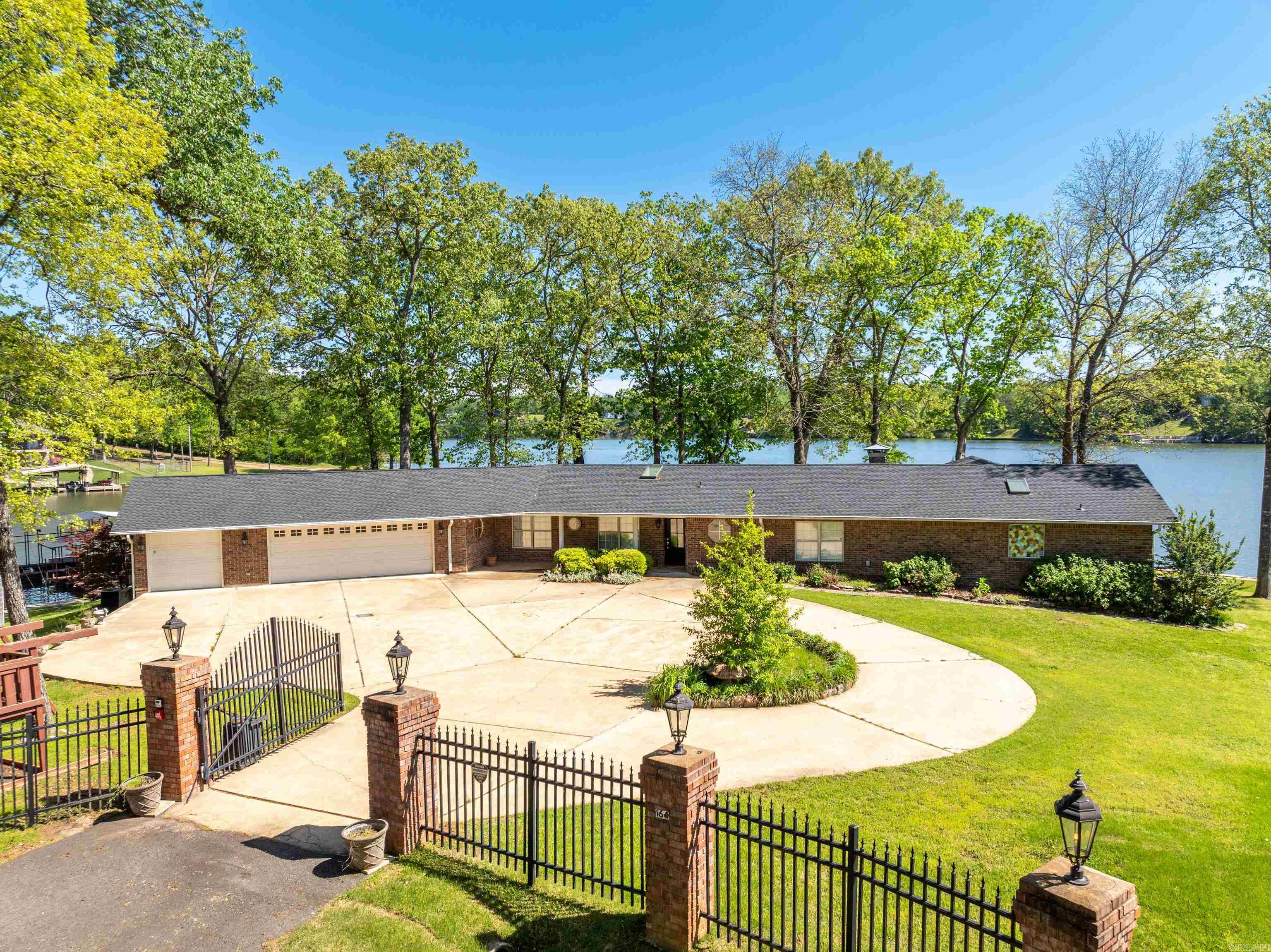 Spectacular Point Property on Lake Hamilton ā 300+ Feet of South-Facing Waterfront! A rare and remarkable opportunity awaits on LakeHamilton! Nestled on one of the few coveted point properties available, this beautifully updated 3-bedroom, 3-bathroom lakefront homeboasts over 300 feet of pristine shoreline, offering panoramic, unobstructed southern views that are simply unmatched. Set on a near-level, gated lot, this stunning residence is designed for both luxurious living and effortless entertaining. The expansive grounds provideample room for outdoor enjoyment or future expansionāperfect for adding a guest house, pool, or additional structures. A spacious,covered patio invites relaxation, while the two-slip covered boat dock and an oversized four-car garage with additional outdoor parkingensure convenience and functionality for hosting guests or storing lake toys. Step inside to discover a thoughtfully renovated interiorwhere modern elegance meets lakeside charm. The heart of the home features a brand-new gourmet kitchen with premium finishes,ideal for both everyday living and hosting memorable gatherings. Natural light pours through skylights, enhancing the open layout andcomple