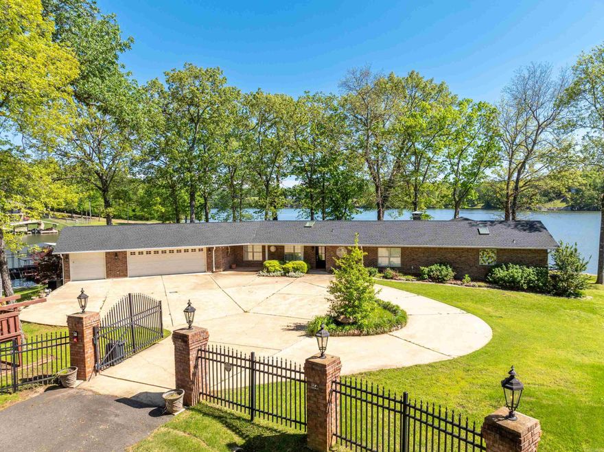 Spectacular Point Property on Lake Hamilton – 300+ Feet of South-Facing Waterfront! A rare and remarkable opportunity awaits on LakeHamilton! Nestled on one of the few coveted point properties available, this beautifully updated 3-bedroom, 3-bathroom lakefront homeboasts over 300 feet of pristine shoreline, offering panoramic, unobstructed southern views that are simply unmatched. Set on a near-level, gated lot, this stunning residence is designed for both luxurious living and effortless entertaining. The expansive grounds provideample room for outdoor enjoyment or future expansion—perfect for adding a guest house, pool, or additional structures. A spacious,covered patio invites relaxation, while the two-slip covered boat dock and an oversized four-car garage with additional outdoor parkingensure convenience and functionality for hosting guests or storing lake toys. Step inside to discover a thoughtfully renovated interiorwhere modern elegance meets lakeside charm. The heart of the home features a brand-new gourmet kitchen with premium finishes,ideal for both everyday living and hosting memorable gatherings. Natural light pours through skylights, enhancing the open layout andcomple