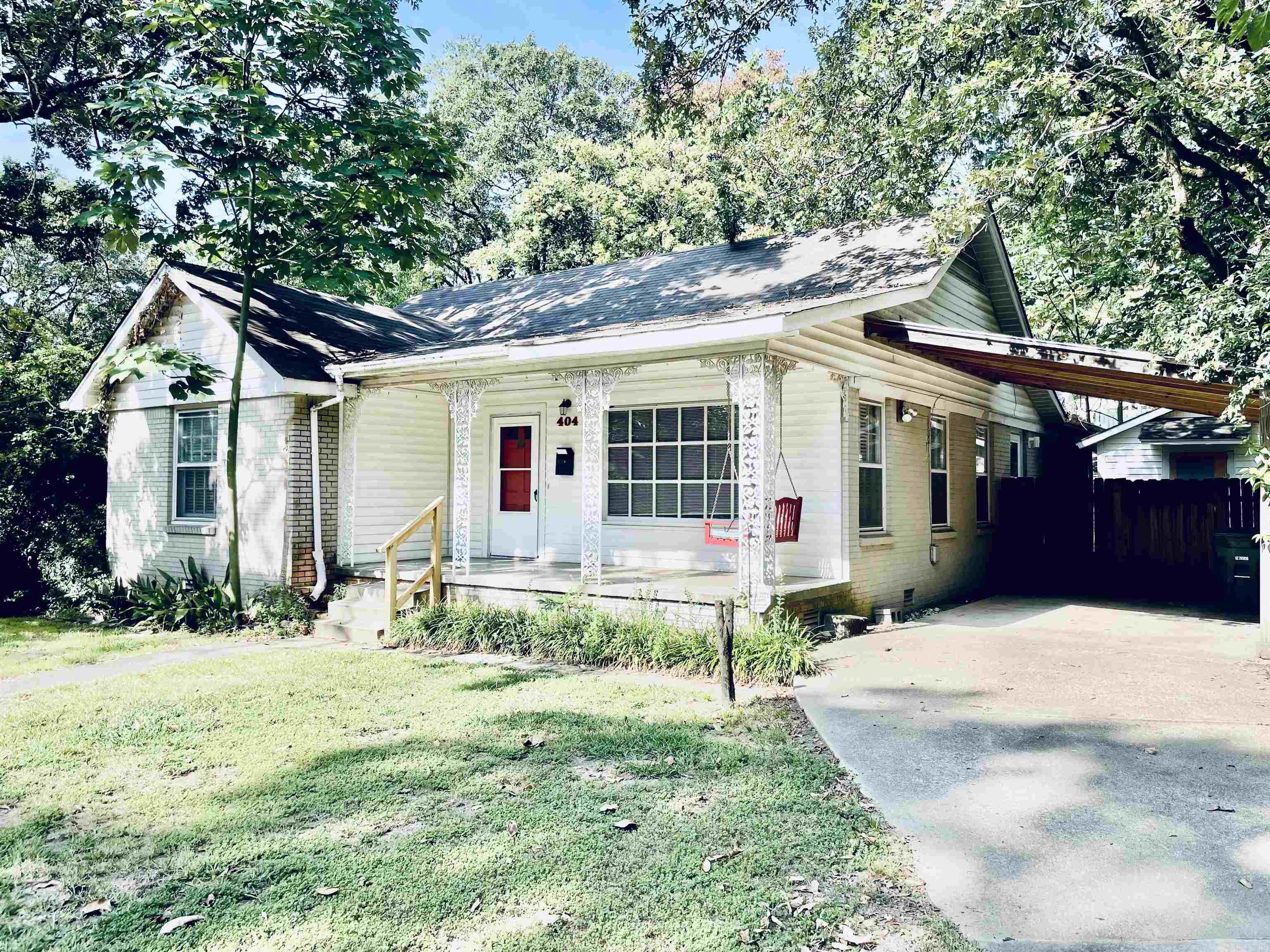 Cure Hillcrest cottage with hardwoods, front porch with porch swing, carport & storage room. Fridge & gas stove in Saltillo tiled eat-in kitchen. 2 bedrooms with full bath with tub-shower combo in-between in front area, back bedroom with full bath has standup shower. Fire pit in shaded, fenced yard with storage room with second fridge. Full sized Washer & dryer connections in hall closet. Decorative FP/picture window in living, separate dining. Walk to grocery, shops and cafes.
