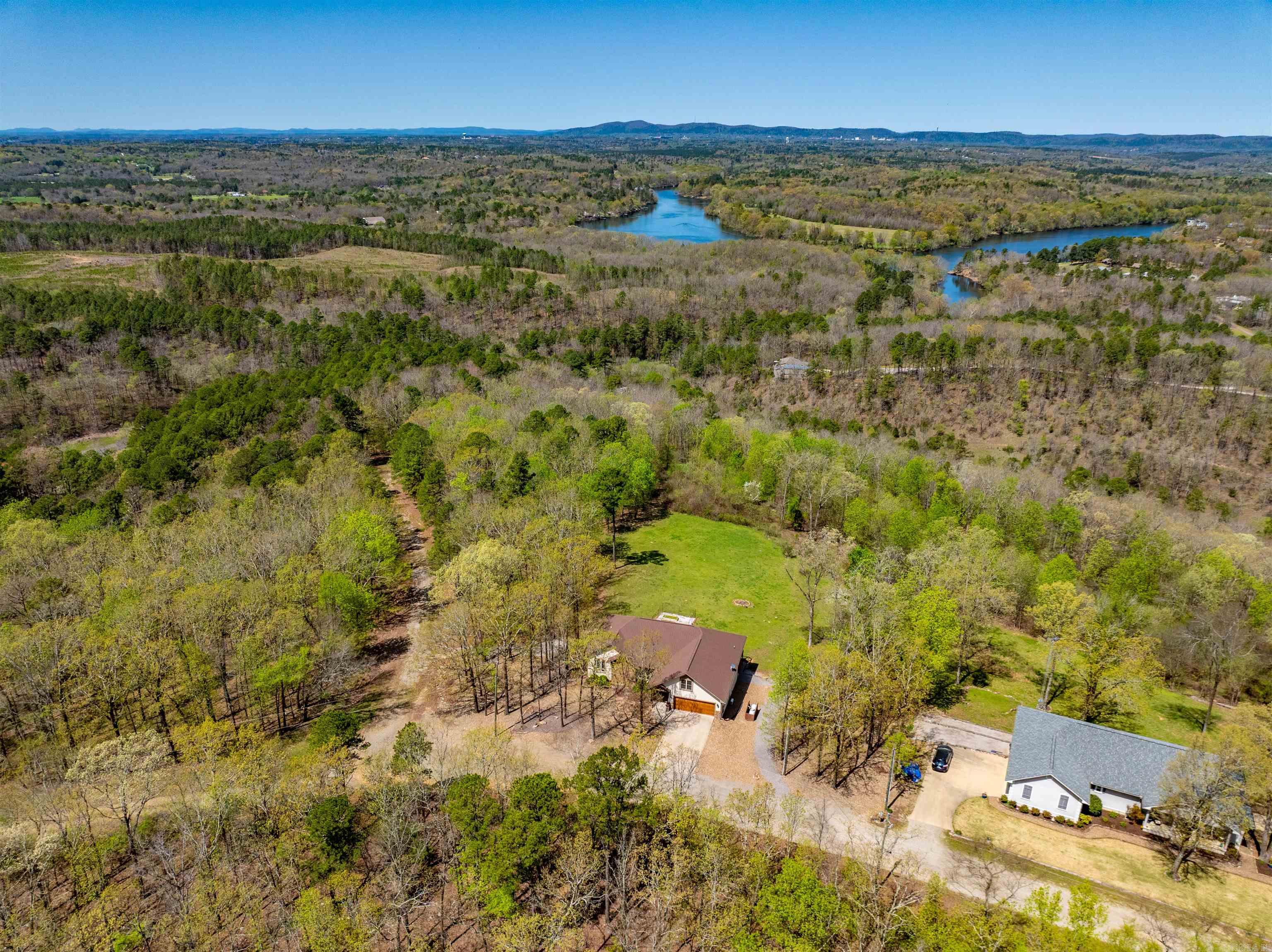 STUNNING VIEWS of the Ouachita Mountains, Lake Catherine, and downtown Hot Springs! This incredible home is packed with features you wonāt want to miss. Walls of windows flood the interior with natural light, offering breathtaking views. The open-concept living, dining, and kitchen area with soaring cathedral ceilings is perfect for entertaining. The spacious primary suite includes a safe room/closet for added peace of mind. Hand-scraped wood and tile floors throughout, plus an upstairs bonus room thatās ideal for an office, game room, or hobby space. All this sits on a serene and private 1.94-acre lot in the highly sought-after Lakeside School District. Opportunities like this do not come around often, do not miss your chance to own this one-of-a-kind property!
