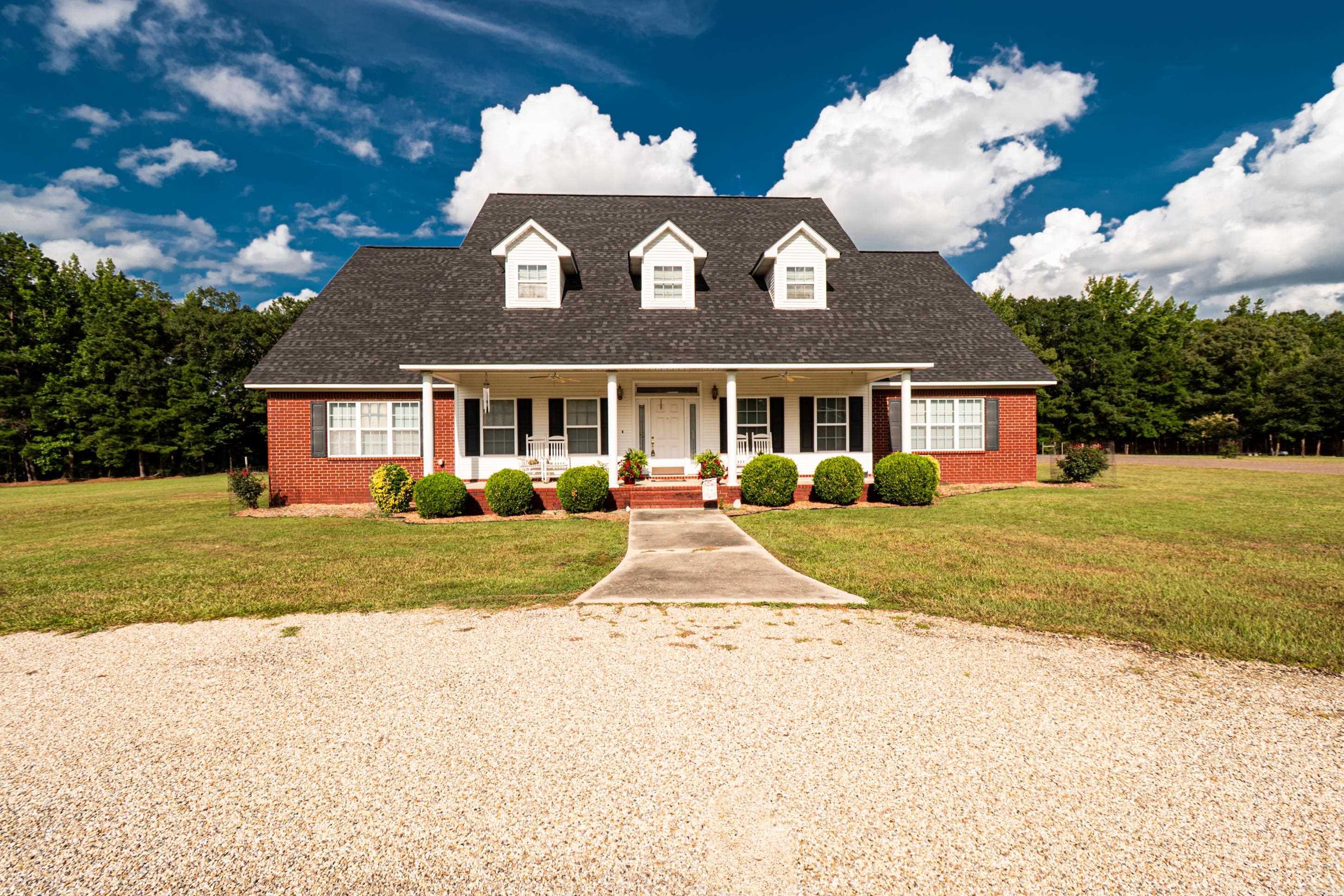 Just listed! This beautiful two-story home is situated on 7.5 acres just outside city limits of Hampton, AR. It consists of 5,255 square feet of Southern elegance! It features beautiful hardwood floors in all living areas, with carpet in the four bedrooms. There are also four bathrooms, two of which have Jacuzzis, and were recently updated with master flush toilets. The large living room is open to the second floor with a balcony around three sides and fireplace with insert. The master bedroom, bath, second bedroom, dining room, large kitchen and breakfast area recently updated with granite countertops, are located on the first floor. You can access the large patio from the living room. Outside, there is a 30x60 workshop with 14 ft. ceilings to accommodate an RV, a half-bath, AC, insulation and electric door, a separate water well for flowers, storm cellar. More updates: new roof of architect shingles, 2025, new hot water tank upstairs, new disposal in kitchen sink and security system. Also, there is a three-car garage.
