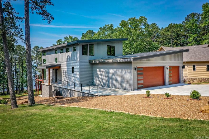Situated on the shores Greers Ferry Lake, this home showcases the perfect fusion of contemporary design & natural beauty. A boat slip can be purchased separately for $35,000. You'll be captivated by the abundance of natural light that fills the rooms. Every detail has been meticulously crafted to create a luxurious living environment that exudes modern elegance. Designed with outdoor living in mind, this home boasts three expansive decks that offer breathtaking views of the lake. Enhancing the outdoor experience, an exquisite outdoor kitchen awaits, complete with a grill, sink & ample counter space. Enjoy the double fire place to relax in the evenings. Additionally, the outdoor shower allows you to rinse off after a refreshing swim in the lake. The kitchen is equipped with quartz countertops, upgraded appliances, pantry & butlers/coffee bar.  The stunning master bedroom bathroom is a luxurious retreat which boasts a deck door that opens up to breathtaking views of the lake, allowing you to savor the beauty of nature. Indulge in pure relaxation in the large soaker tub. The custom closet is a true masterpiece, featuring hydraulic clothes rods.  This home has been virtually staged.