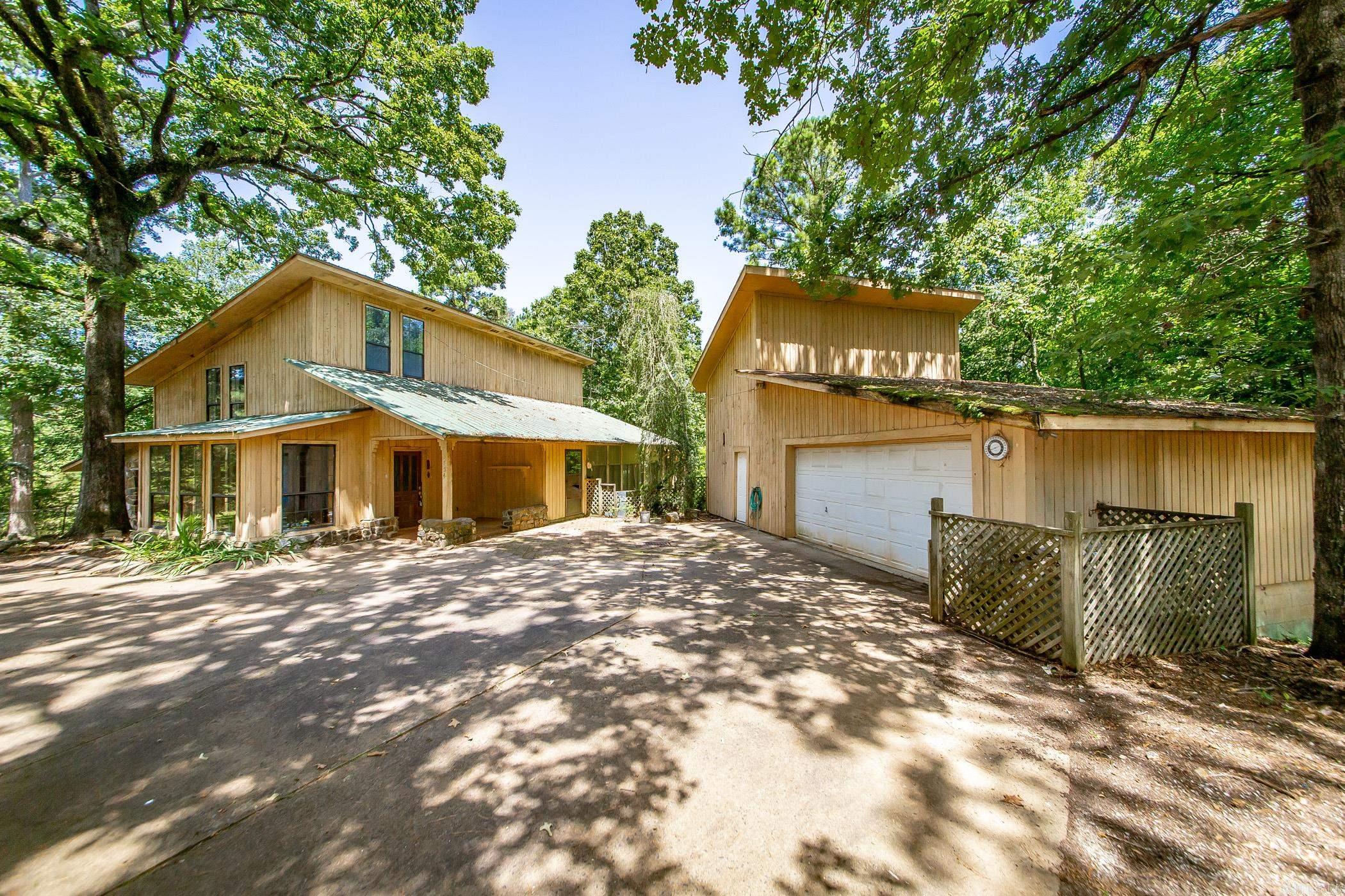 This unique, custom-built home offers the perfect blend of privacy, charm, and functionājust 3 miles from the Point Cedar boat ramp on Lake DeGray. With 2,225 sq ft of living space, the home features 2 bedrooms, 2.5 bathrooms, a large pantry, and a one-of-a-kind layout designed for comfort and flexibility. A cozy wood-burning stove adds warmth and character, while the sunroom and wraparound screened-in porch provide the perfect spaces to relax and take in the natural beauty around you. Situated on 6.5 acres with a fenced backyard, the property also includes a separate home site with septic already installedāideal for a guest house, future build, or investment opportunity. A spacious 22x35 garage/workshop offers room for projects, storage, or lake gear. Bonus: the sellers are including matching LVP flooring for the upstairs, ready for new owners to install. Donāt miss your chance to own this one-of-a-kind property near the water, with room to roam and room to grow!