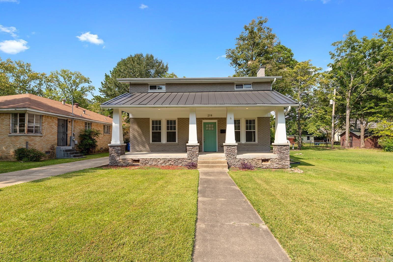 Welcome to 219 W D Ave. A beautifully preserved 1933 craftsman-style home nestled in the heart of the Park Hill Historic District. From the moment you step onto the oversized front porch with its stone columns and wide steps, you'll feel the old world charm blended effortlessly with stylish, modern updates. Featuring hardwood floors, tall windows, rich trim, and a spacious open layout, this home was made for both relaxing and entertaining! The bright, updated kitchen includes granite countertops, stainless steel appliances, and a large breakfast bar that opens into the dining and living areas. Downstairs offers a guest bedroom + full bath, while upstairs features a private primary suite with a walk-in closet, soaking tub, tiled shower, and a second large guest suite with its own bathroom! Enjoy a relaxing evening on the wide front porch, or host friends in the backyard with deck access and a detached 2-car garage. All this in the Park Hill Historic District, while a short distance to dining and just minutes from LRAFB, downtown Little Rock, Simmons Arena & much more.