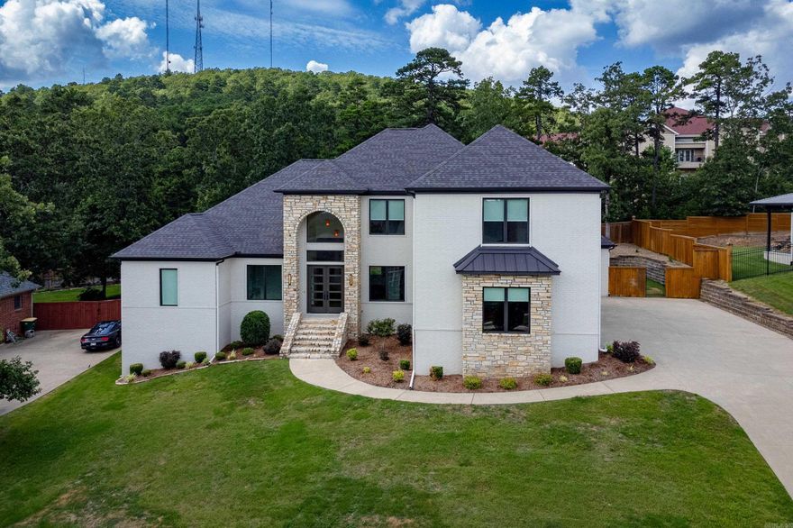 Gorgeous home with custom natural finishes in exclusive Deauville Place gated community adjacent to golf course. Open floor plan with abundant natural light showcases the brand-new hardwood floors and new carpet on entire main level!! Custom chef’s kitchen with quartz countertops, commercial gas range, double ovens, top-of-the line alkaline water filtration system & more. Russound surround sound system throughout house, including on spacious covered patio with custom resin floors and fireplace, perfect for relaxing or entertaining friends & family! Retreat after a long day to the enormous owner’s suite with spa-like master bath with soaking tub and spacious walk-in closet. Upstairs bonus room has 120-inch screen, surround sound & wet bar for movie or game nights. Enjoy access to 3 pools with kids’ splashpad included with HOA dues, just minutes away without the cost and hassle of pool maintenance! Don’t miss this spectacular home, centrally located in Chenal Valley!”