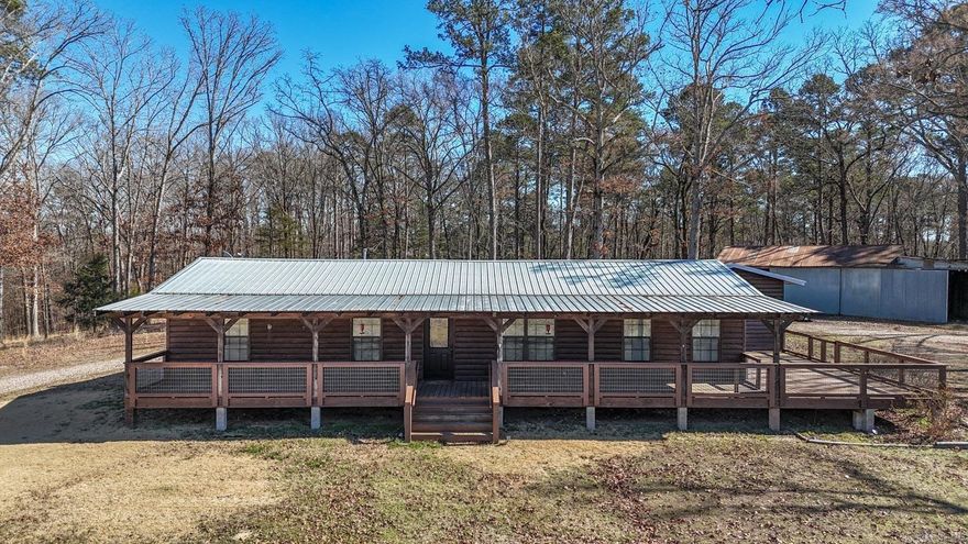 Move-in ready ranch-style home on 4.6 acres m/l in Mena, AR, just minutes from Talimena State Park, Ouachita National Forest, and ATV trails. This well-maintained 3 bedroom, 2 bath home features a metal roof, log wood siding, open-concept floor plan, and large living room. The functional kitchen offers abundant cabinets and pantry storage. Enjoy a covered front porch that wraps around to the south and a large back patio and a  firepit. Patio doors lead from the primary bedroom to south porch. Bonus room ideal for office or craft space. Oversized laundry/mud room and spacious bedrooms and closets. Property includes large shop building, rural water plus private well option, this property suitable for primary residence  short-term rental, or vacation retreat. Excellent opportunity for those searching for home with acreage in Mena, Arkansas property near National Forest, or investment Airbnb near Talimena Scenic Drive.