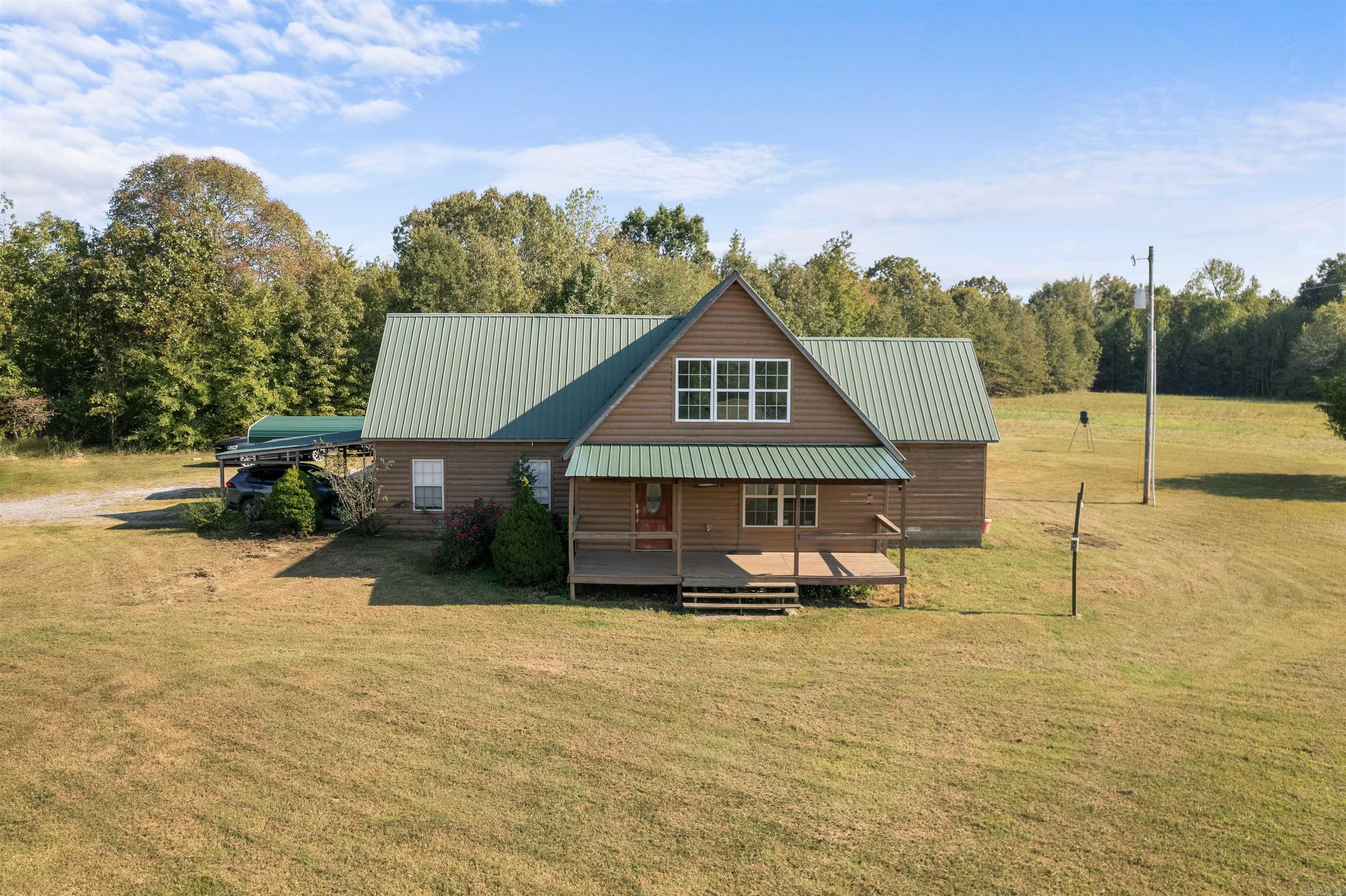 Ready for Life at the End of the Road? Welcome Home! This country cabin look home is a 3-bed, 1-bath, approx 2,208 sq ft home situated on approx 14.65 acres boasting 2 spacious shops, a small pond and more! Entering the home one notices the large living room w/vaulted ceilings and significant natural light w/a delicate balance of light & dark tones. Just off the living room is the galley style kitchen w/ample storage and large enough for two refrigerators. The home has a dining and living room combination. Two bedrooms are downstairs and one bedroom upstairs. Outside the home one can enjoy covered front and rear porches to take in the country scene and wildlife. Need to store your toys out of the elements? Well, this property has a large 40x50 shop w/bay doors and also has a large 25x30 two car detached garage/shop too! The property is approx 14.65 acres mainly fields but has some tree coverage too w/small pond also.  You will want to checkout all the potential this could have for you!  Come view the home and property and make an offer!  See Agent Remarks.