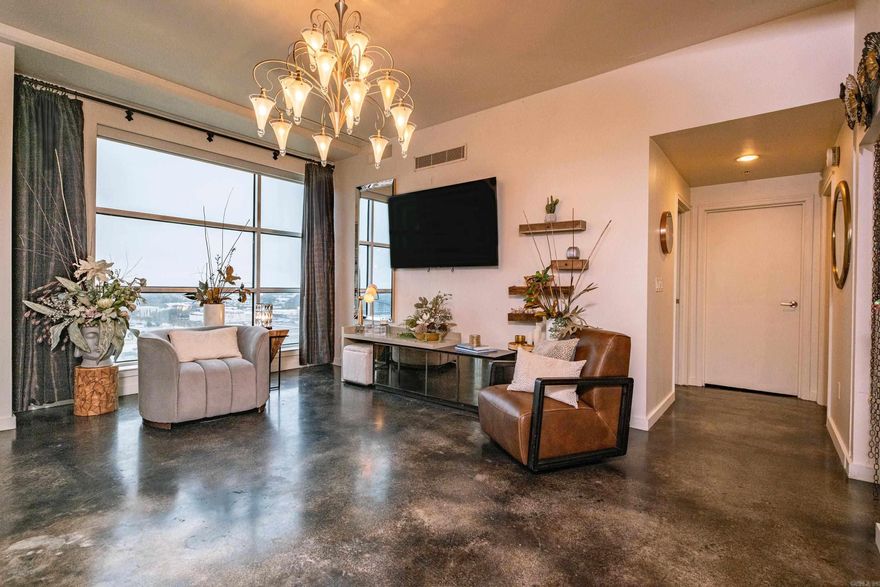 Well appointed condo in the heart of Little Rock's downtown River Market District. Floor to ceiling windows with beautiful views. Covered patio. Stained concrete floors throughout. Cook's kitchen with pretty stained cabinets, granite countertops, built in dishwasher and microwave. Breakfast bar plus serving bar.  Nice great room with electric fireplace. Spacious master bedroom with built in armoire plus closet.  Bath has walk in shower and granite countertops. Very secure building with FOB only access to the building, the elevators and to your floor. One parking space, in gated secure street level garage. Convenient to wonderful restaurants & entertainment. You will love being in the middle of the walkable River Market district. The Clinton Library is just a few blocks away, along with East Village area. This building offers a full-service hotel on the lower level for out of town guests featuring a Starbucks and Bar. Furniture could be available to purchase. Drapes convey.