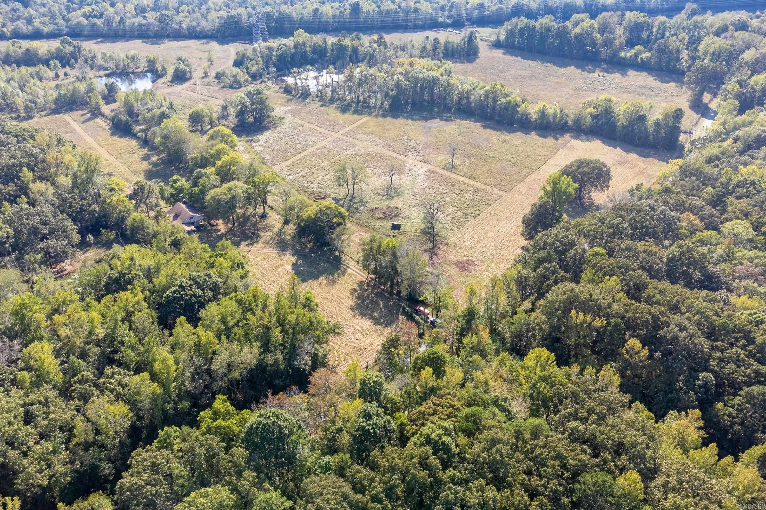 Wonderful flat 54 acres in West Pulaski County perfect for cattle or horses. Acreage is cleared & fenced w/ 2 ponds. Located in a grove of trees, the home has 4 bedrooms 2.5 baths, along w/ a formal living rm, den & hardwood floors. Home is perfect for a remodel or use as a guest house. Property also has a lrg shop & barn. Located 12 minutes from Chenal Parkway/Rahling Road & 15 minutes from I430. The tract could be purchased w/2 additional parcels for a total of 56+/- acres on the North side of Barry Lane