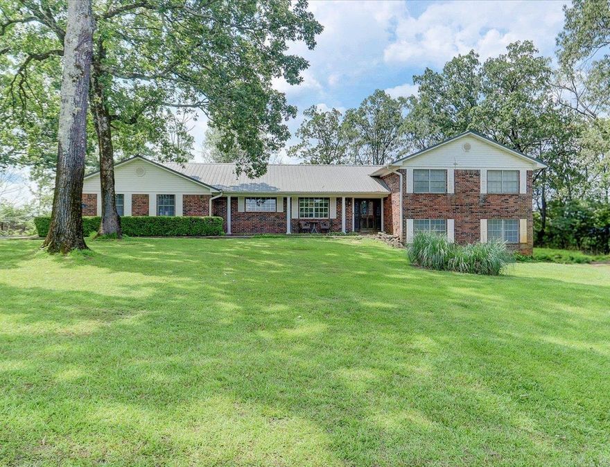 Imagine Life with Lake Views, Seclusion, and Space — All Just Minutes from Town. Welcome to your private sanctuary in the heart of Hot Springs. As you pull into the gently winding driveway, you're immediately embraced by the peaceful surroundings & mature trees, open green lawn, and the sparkling backdrop of Lake Hamilton just beyond. Step onto the covered front porch, take a deep breath, and imagine sipping your morning coffee here, listening to the birds, with the lake shimmering in the distance. Inside, the home unfolds into over 3,040 SQ FT of comfort and charm from the inviting formal living room to the warm and rustic family room with a real wood-burning fireplace, perfect for cozy evenings and game day gatherings. The dedicated office offers a quiet escape to focus or unwind with a book, while the formal dining and breakfast rooms give you flexibility for hosting guests or enjoying a peaceful family meal. Downstairs, a 900SQ FT basement workshop or hobby room is ready for whatever fuels your passion, woodworking, crafts, workouts, or storage. And with RV hookups, a separate detached garage, and a fenced backyard, the property truly fits every part of your lifestyle.