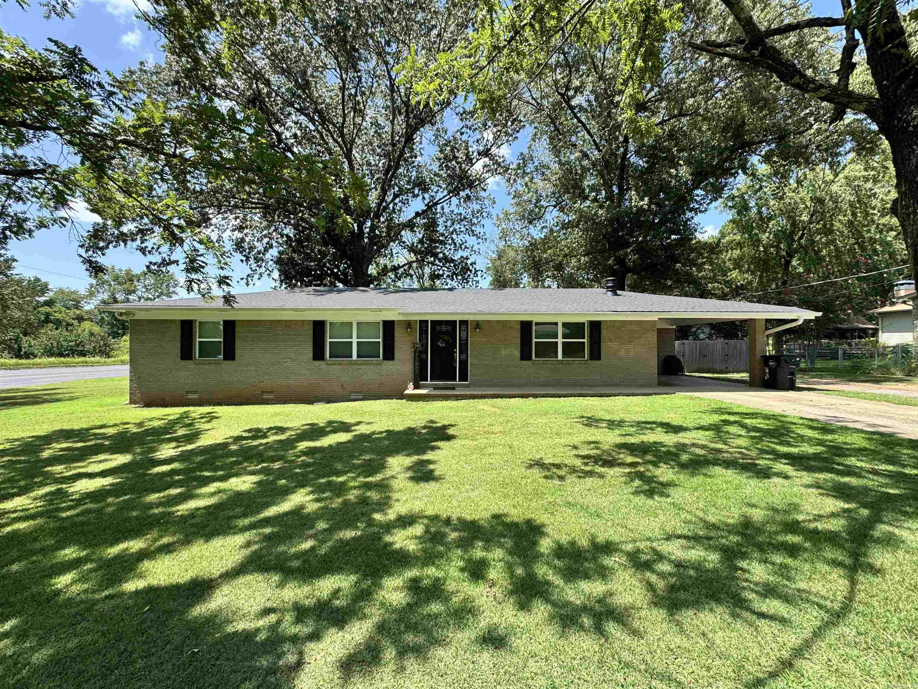 This beautifully updated brick home sits on a large corner lot just outside the city limits. Open concept living, dining, kitchen with a beautiful stone fireplace. Primary bedroom with ensuite bath. Updated kitchen with granite countertops. Large covered back porch overlooking a large fenced back yard. Beautiful large level lot. HVAC 1 year old. Additional 16x16 metal building with roll up door in back, perfect for storing tools or a mancave. This house is pristine. Brand new roof!