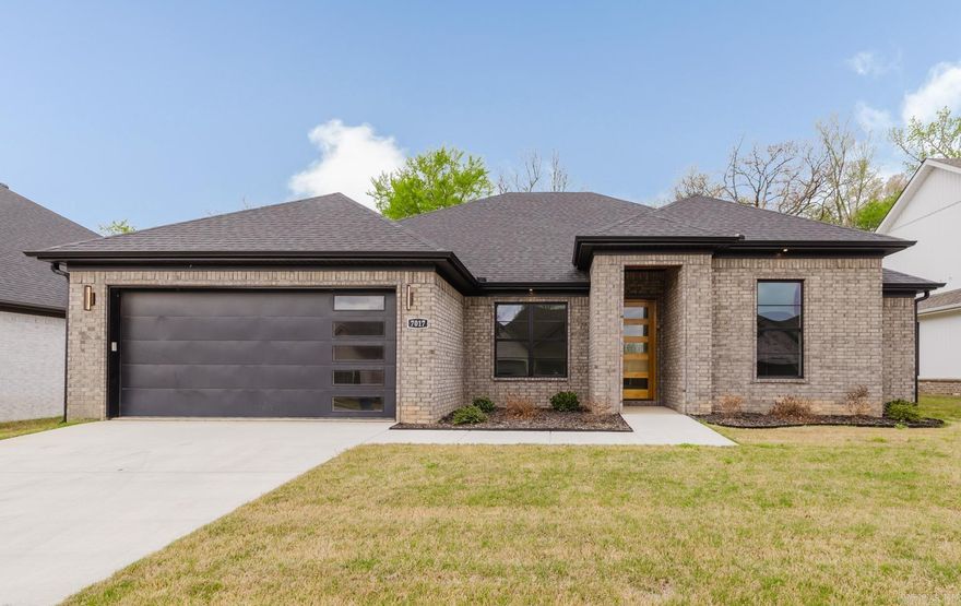 Light-filled and inviting, this contemporary home features an open living area with soaring ceilings and a sleek modern electric fireplace. The kitchen offers abundant cabinetry and a spacious island—perfect for casual dining or entertaining. A split floor plan provides a private primary suite with a generous closet and bath, along with a well-appointed laundry room and covered back patio. Located in Creekside within the Bryant School District. Built by an experienced local builder.