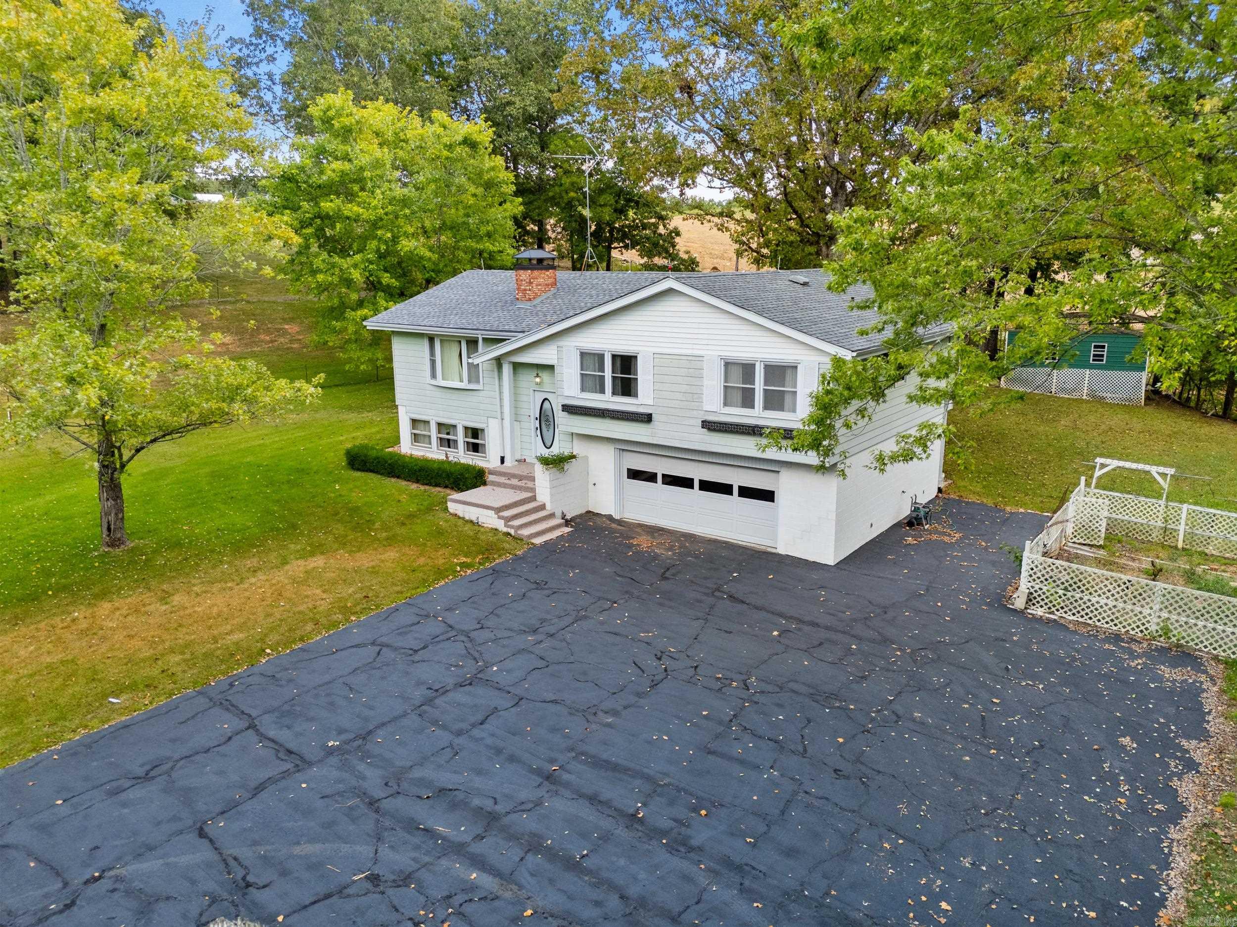 This well-kept 4 bedroom, 2.5 bath home sits on 9.44 acres m/l with prime Highway 62 East frontage, only 2 miles from Mountain Home and just minutes from Norfork Lake. A paved, gated driveway leads to the residence, which offers two cozy wood-burning fireplaces, a welcoming layout, and a cared-for condition inside and out. The land includes some fenced pasture, ideal for animals or gardening, along with a handy storage shed. Major updates provide peace of mind with shingles replaced in 2024 and an HVAC unit updated in 2018. With a blend of privacy, accessibility, and usable acreage, this property is perfect for country living near town and the lake.